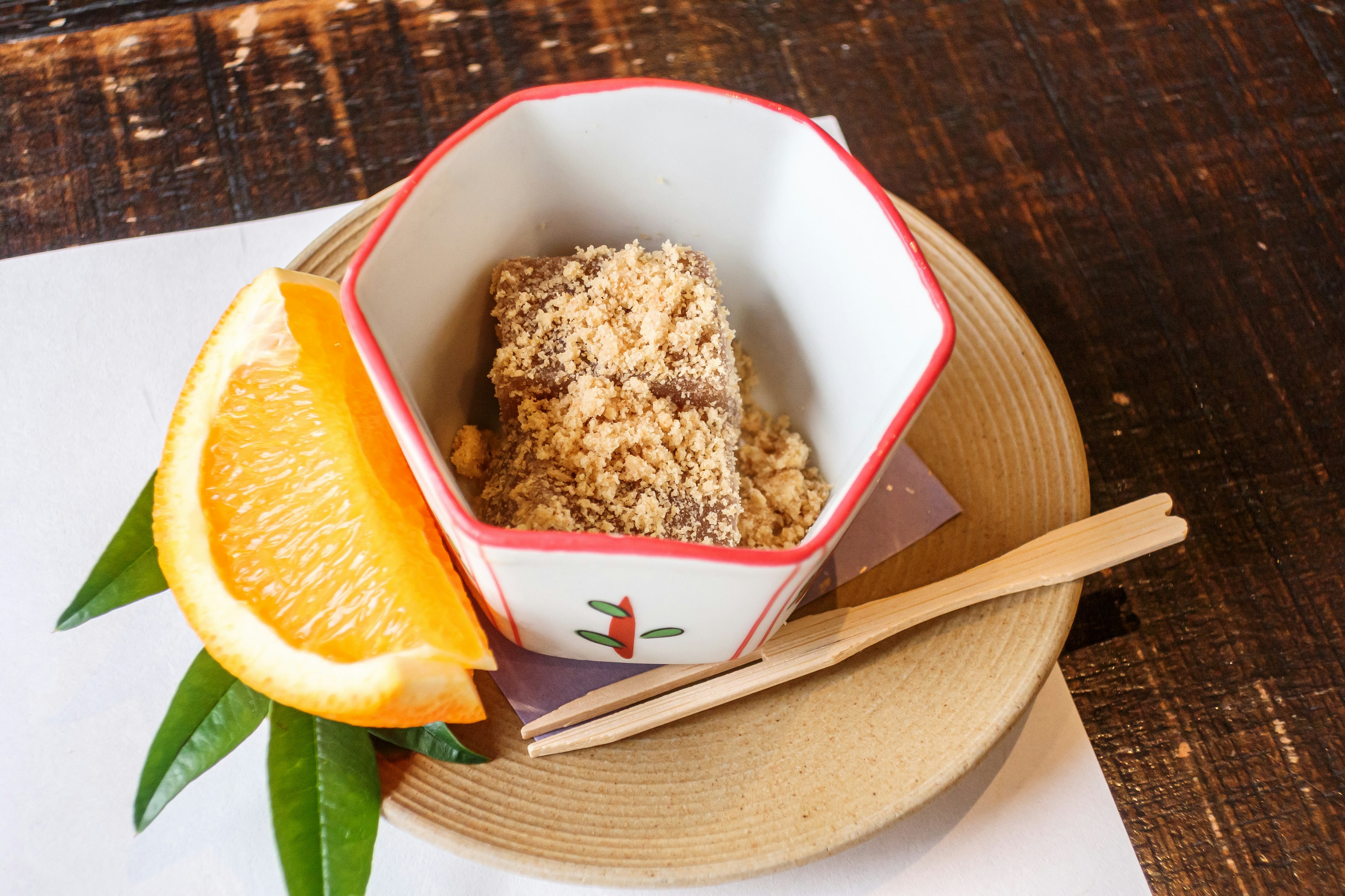 Japanese dessert served with a slice of orange and leaves