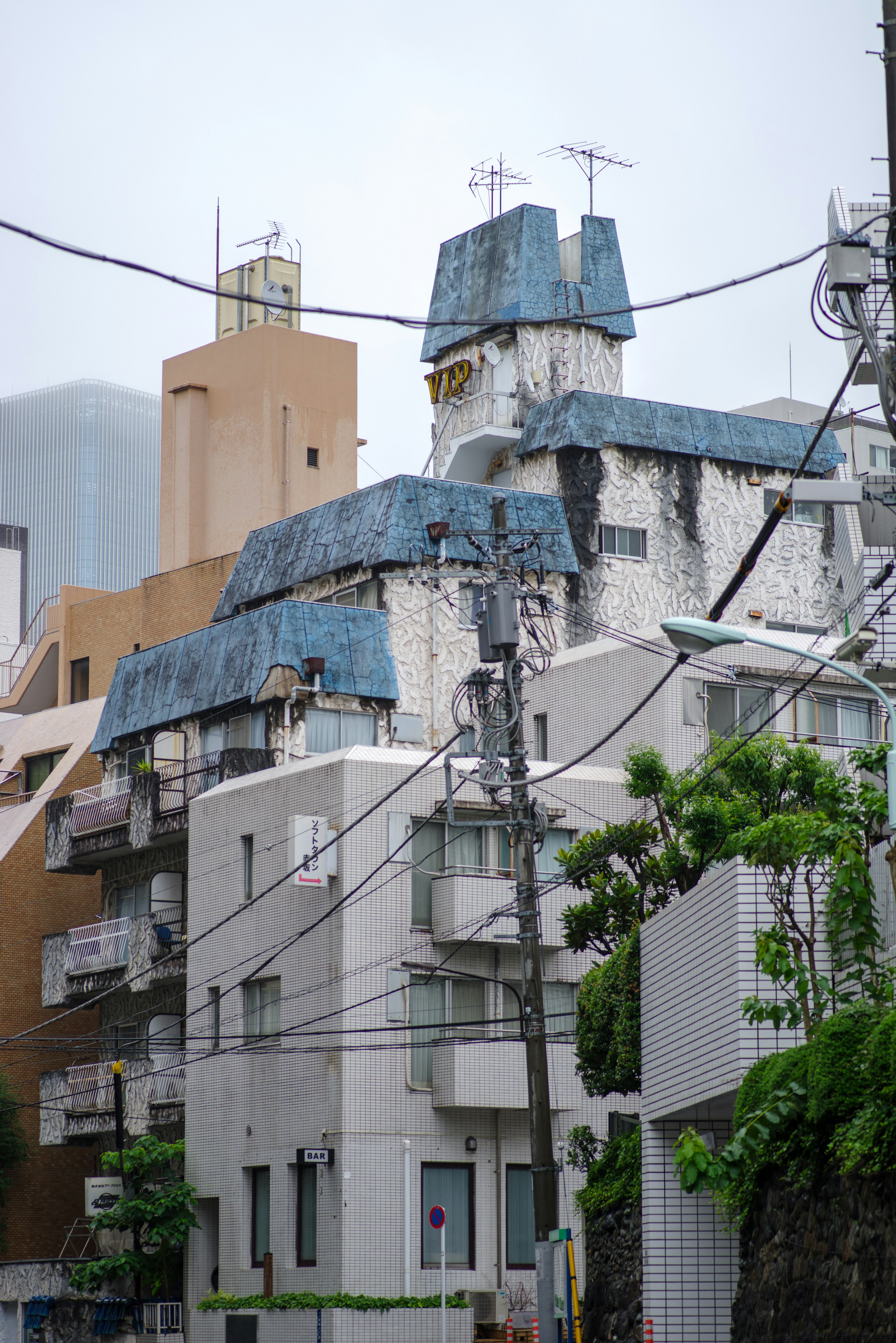 Edificio unico con tetto blu e area residenziale circostante