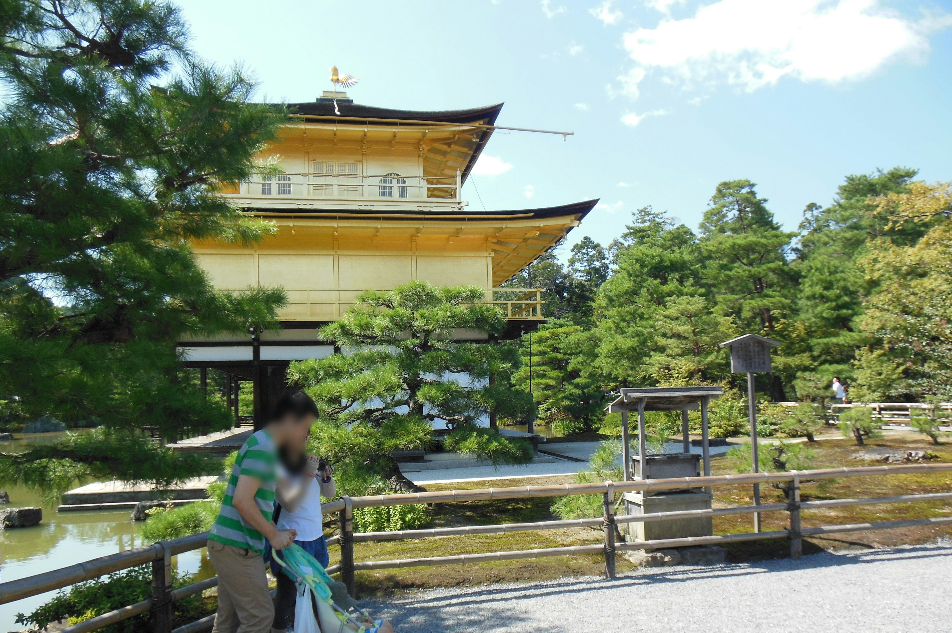 Turistas frente al hermoso templo Kinkaku-ji y jardín