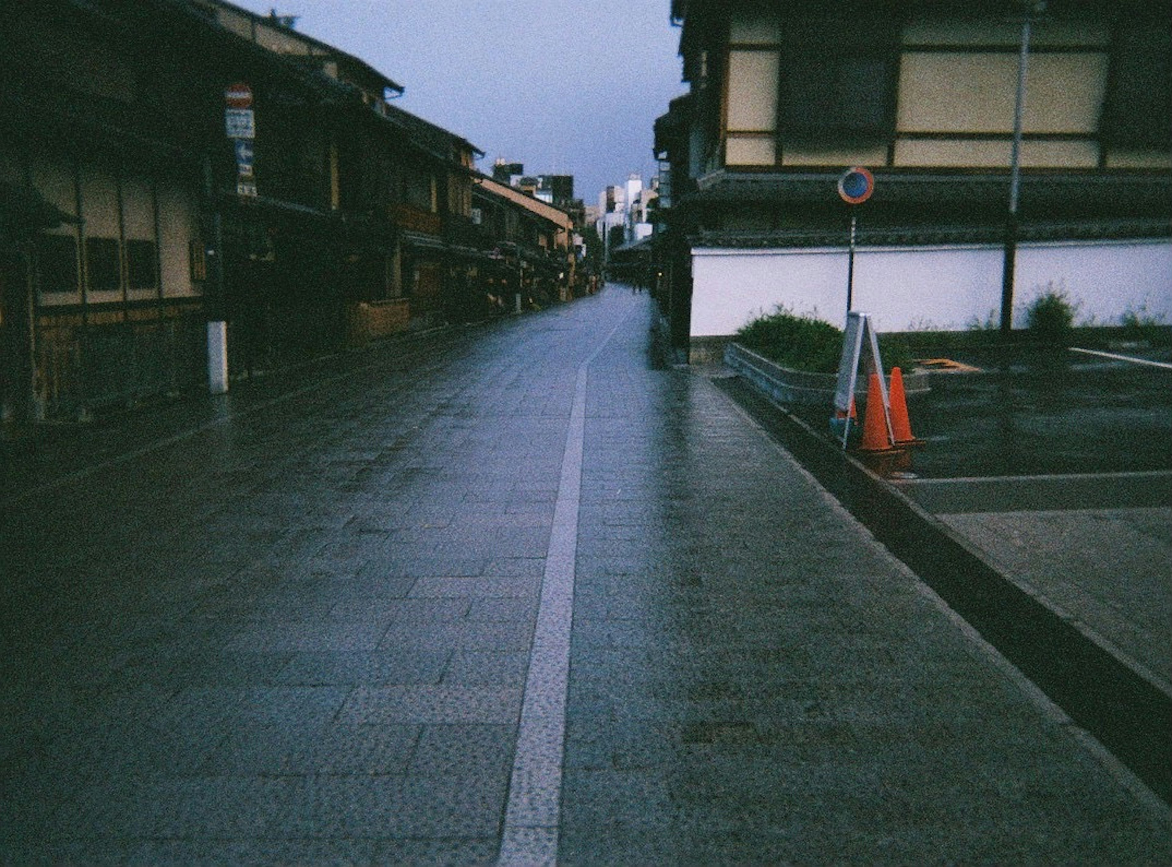 Quiet street with wet pavement and traditional buildings