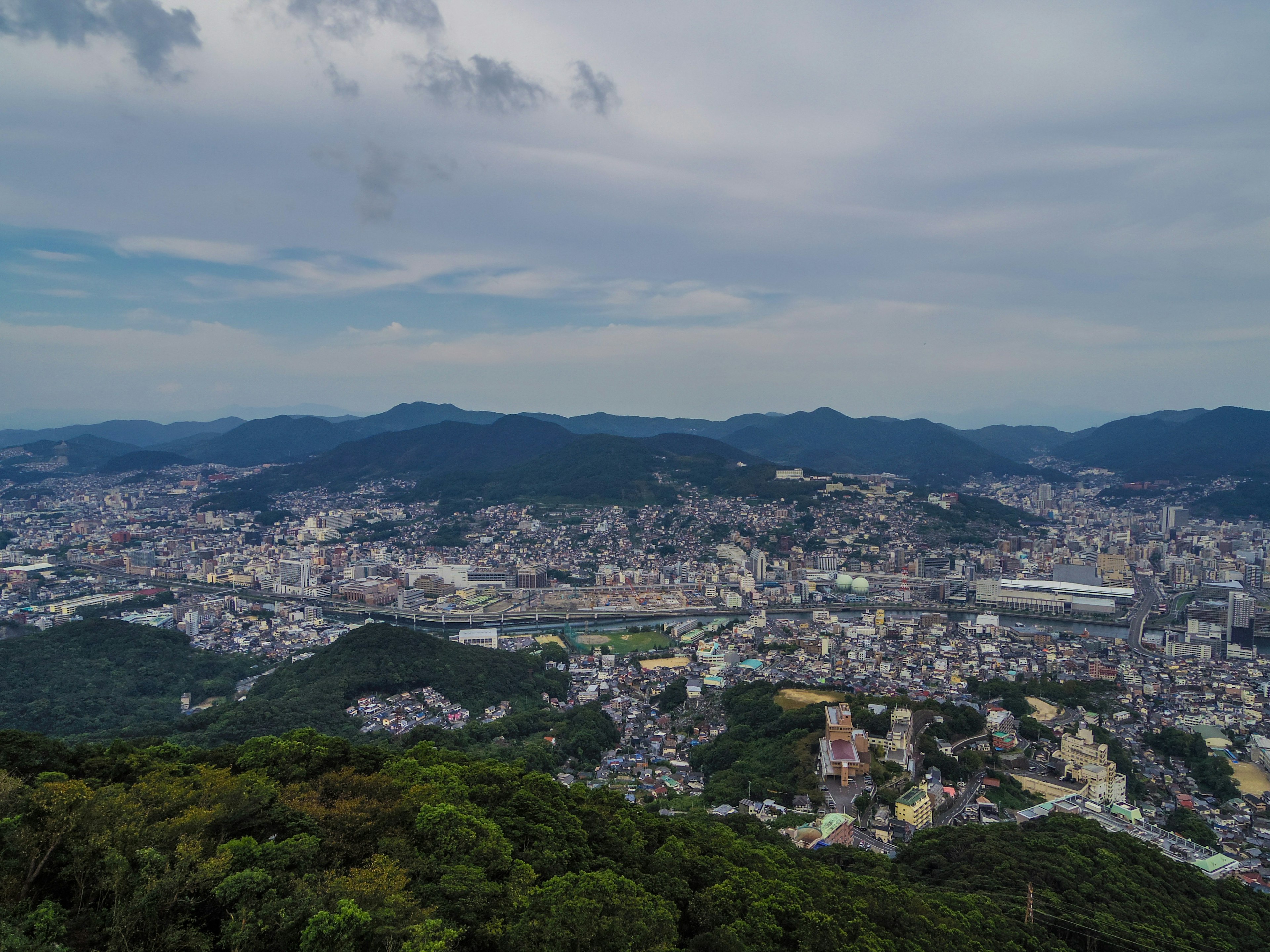 Panoramablick auf eine Stadt von einem Berg mit üppigem Grün