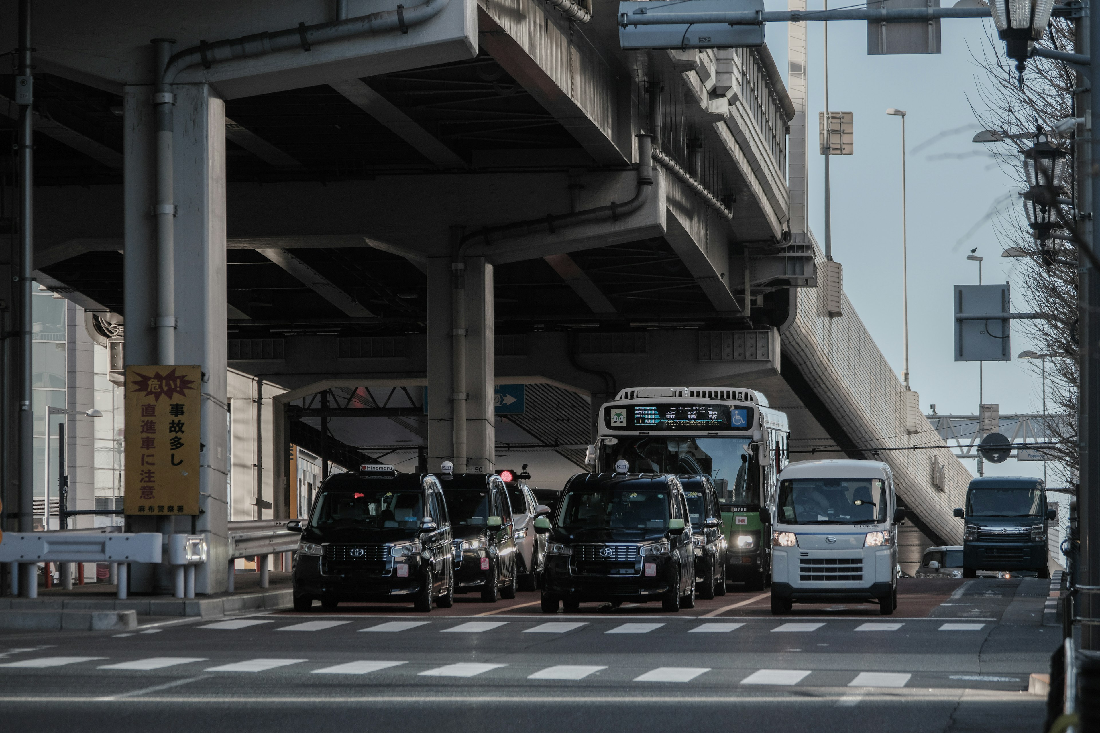 Urban traffic scene with vehicles and a bus under an overpass