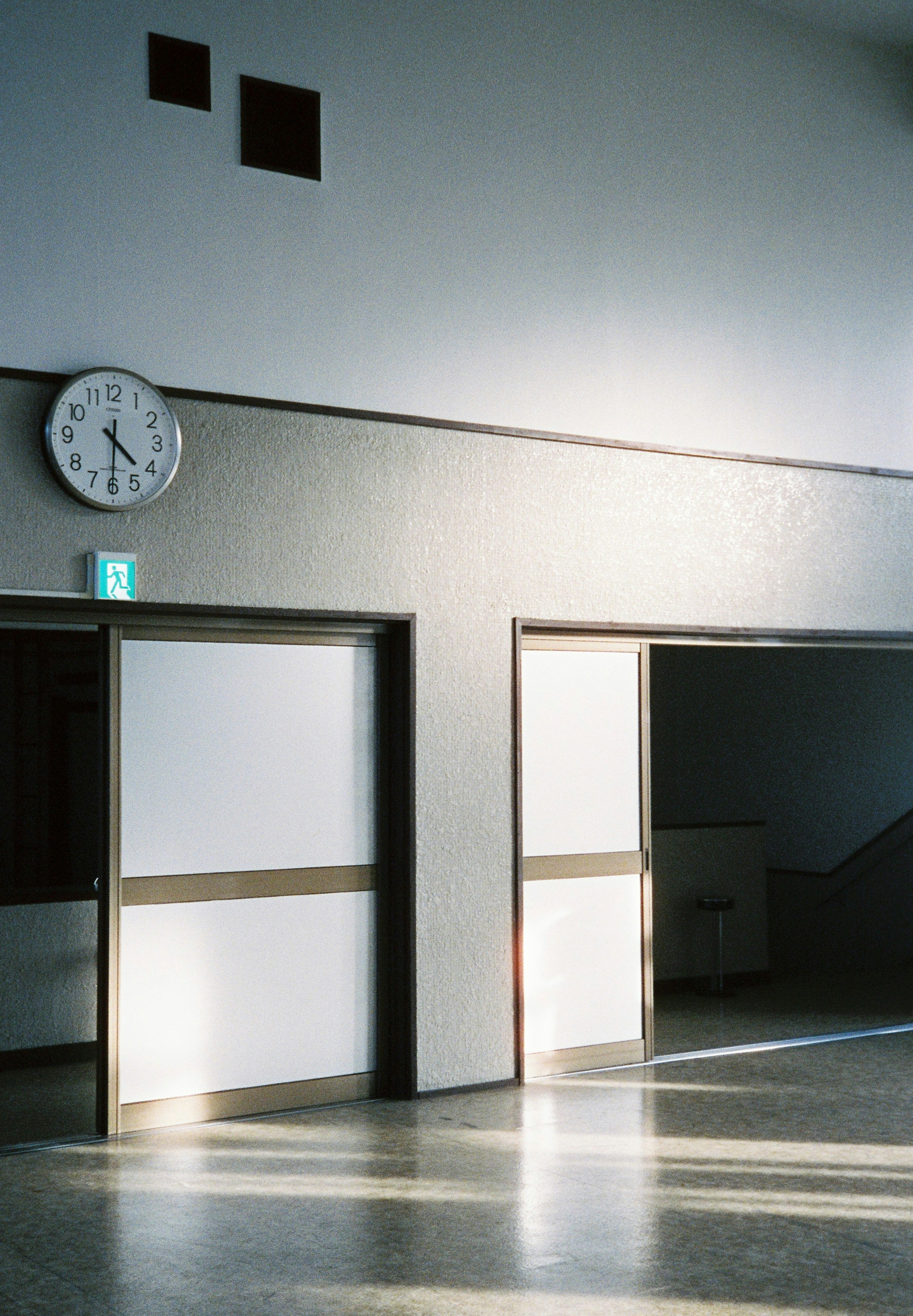 Angolo interno luminoso con porte bianche e un orologio