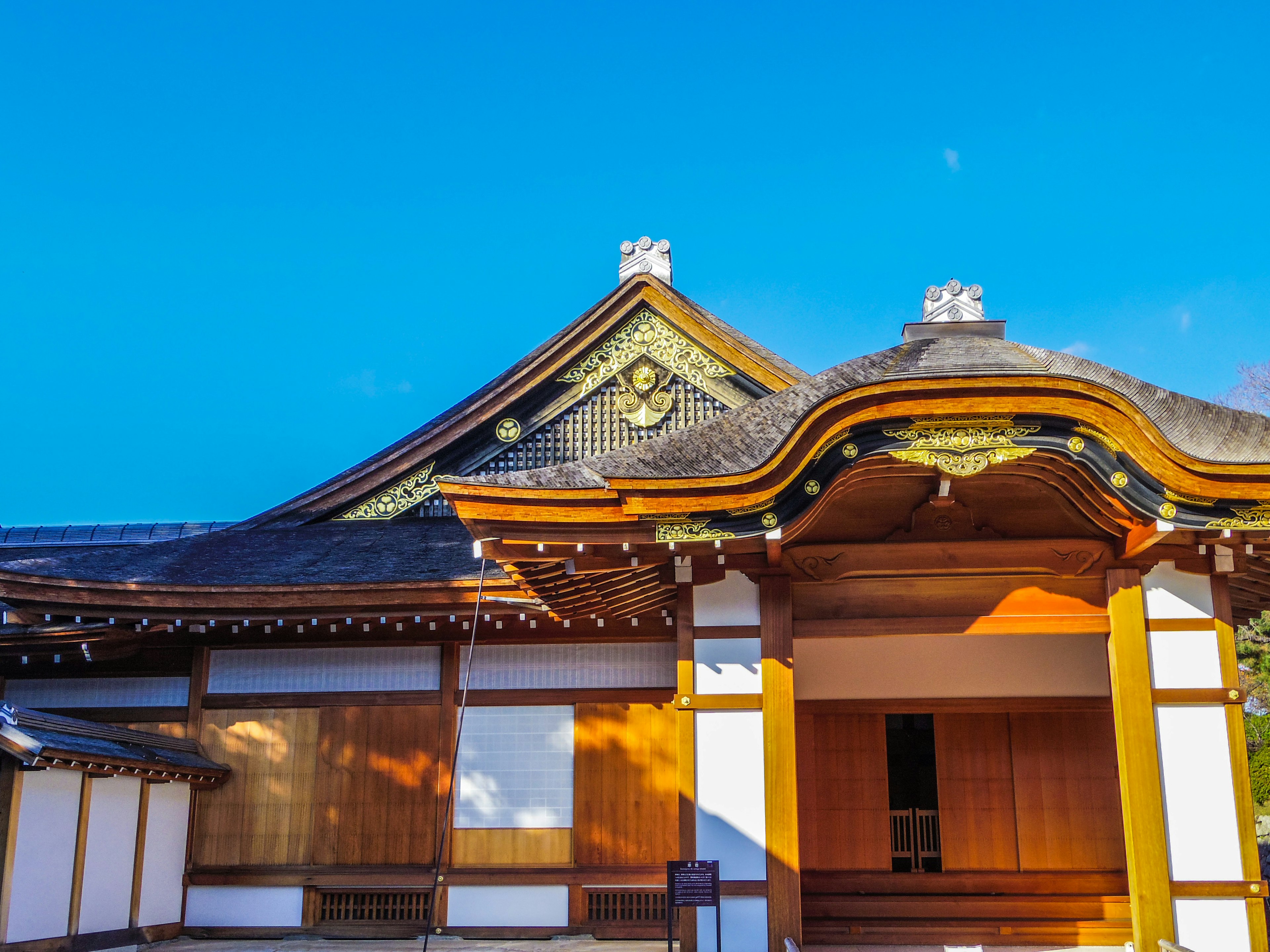 Traditional Japanese building with intricate roof design under blue sky