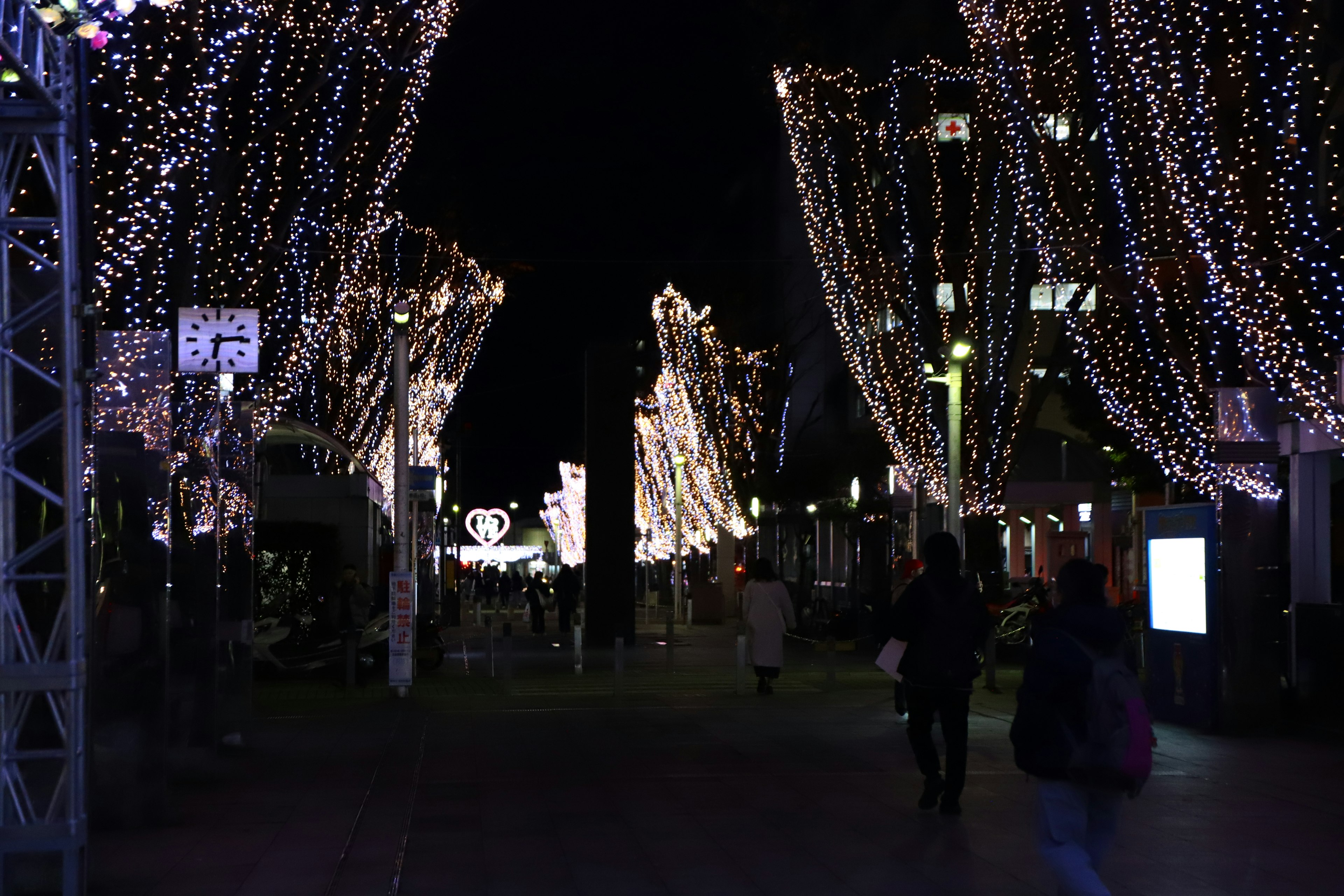 Straße mit festlichen Lichtern bei Nacht beleuchtet