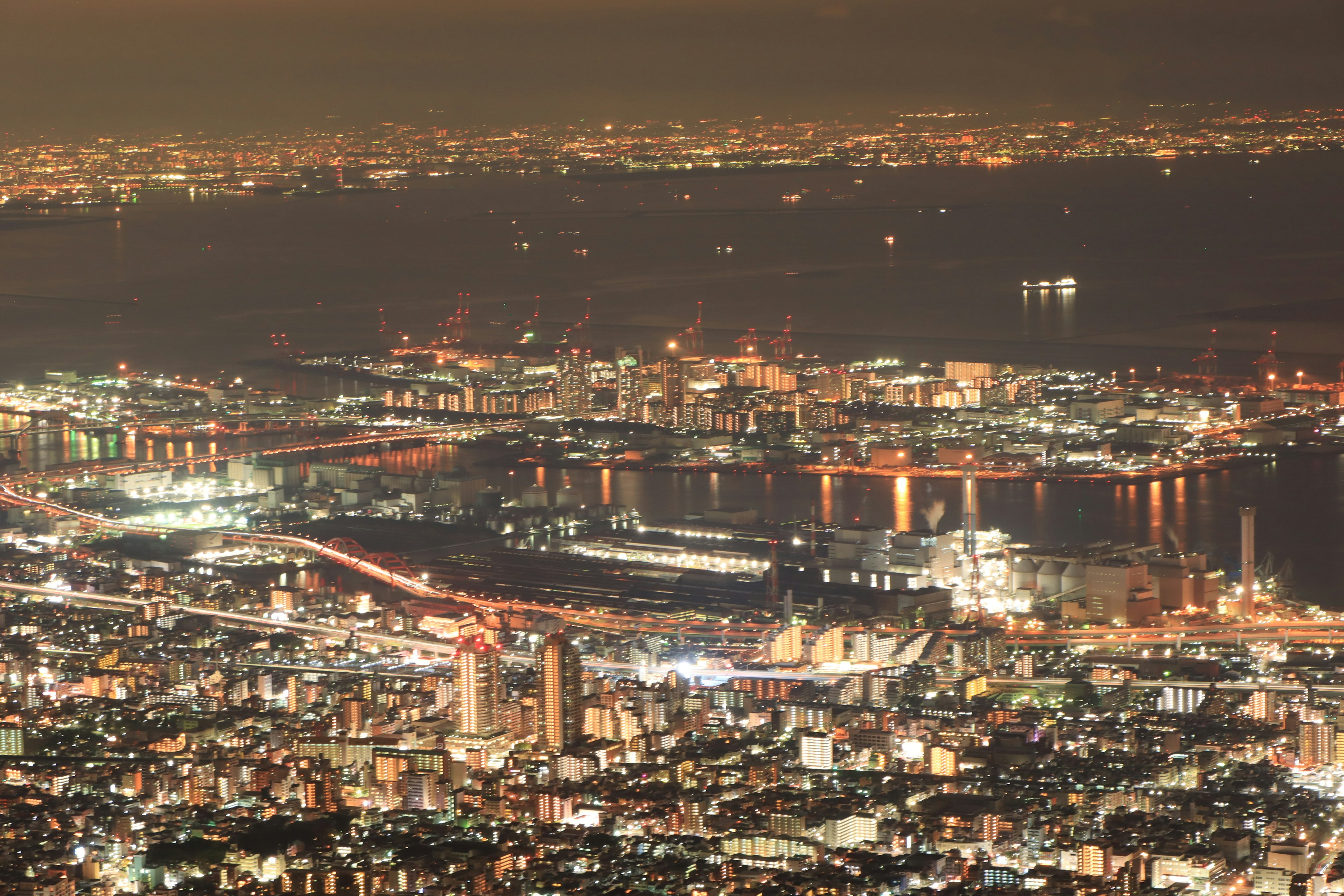 Paisaje urbano nocturno con luces centelleantes, puerto y edificios extensos