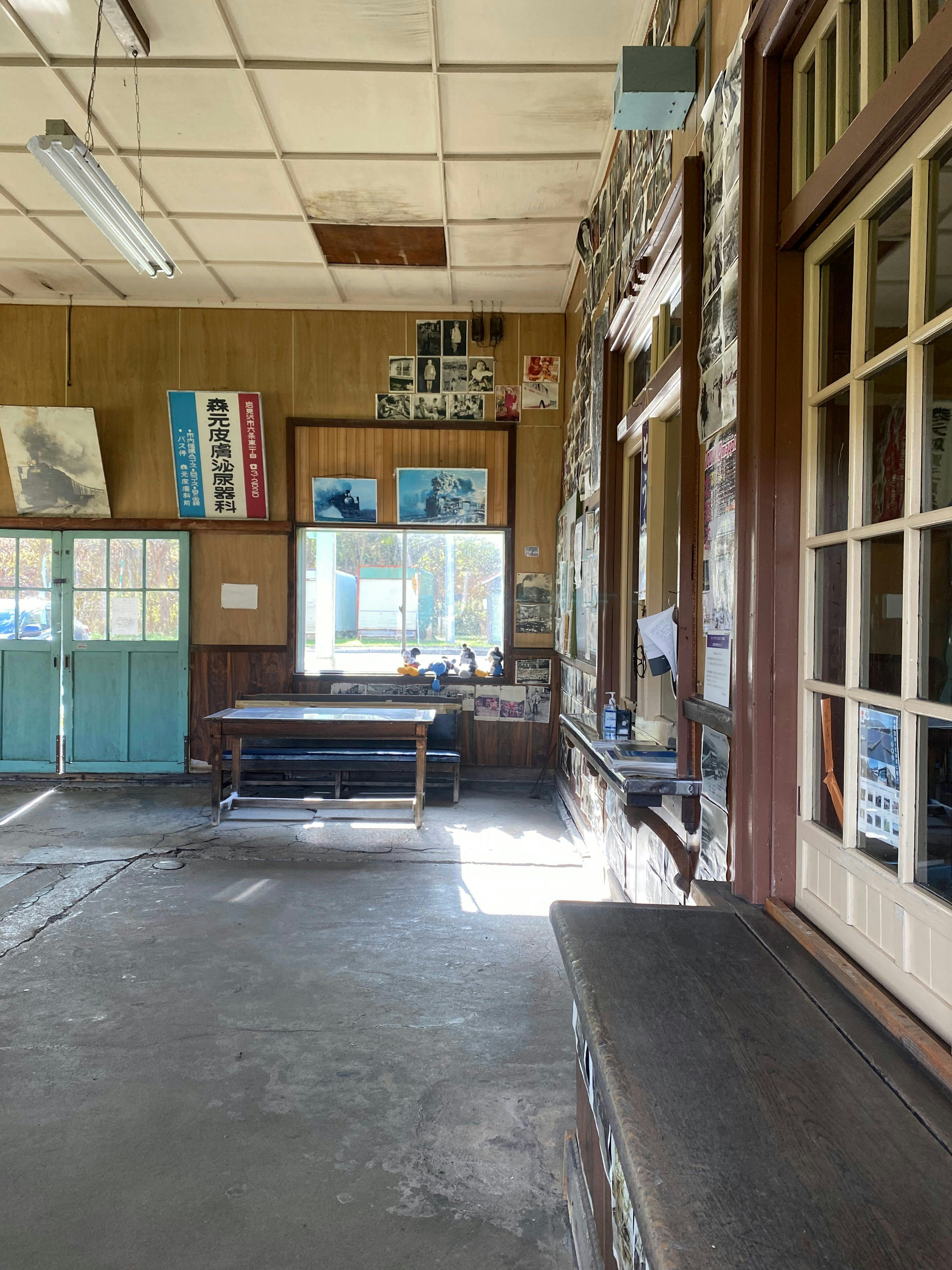 Innenansicht eines alten Klassenzimmers mit Fotos und Postern an den Wänden natürliches Licht, das durch die Fenster kommt