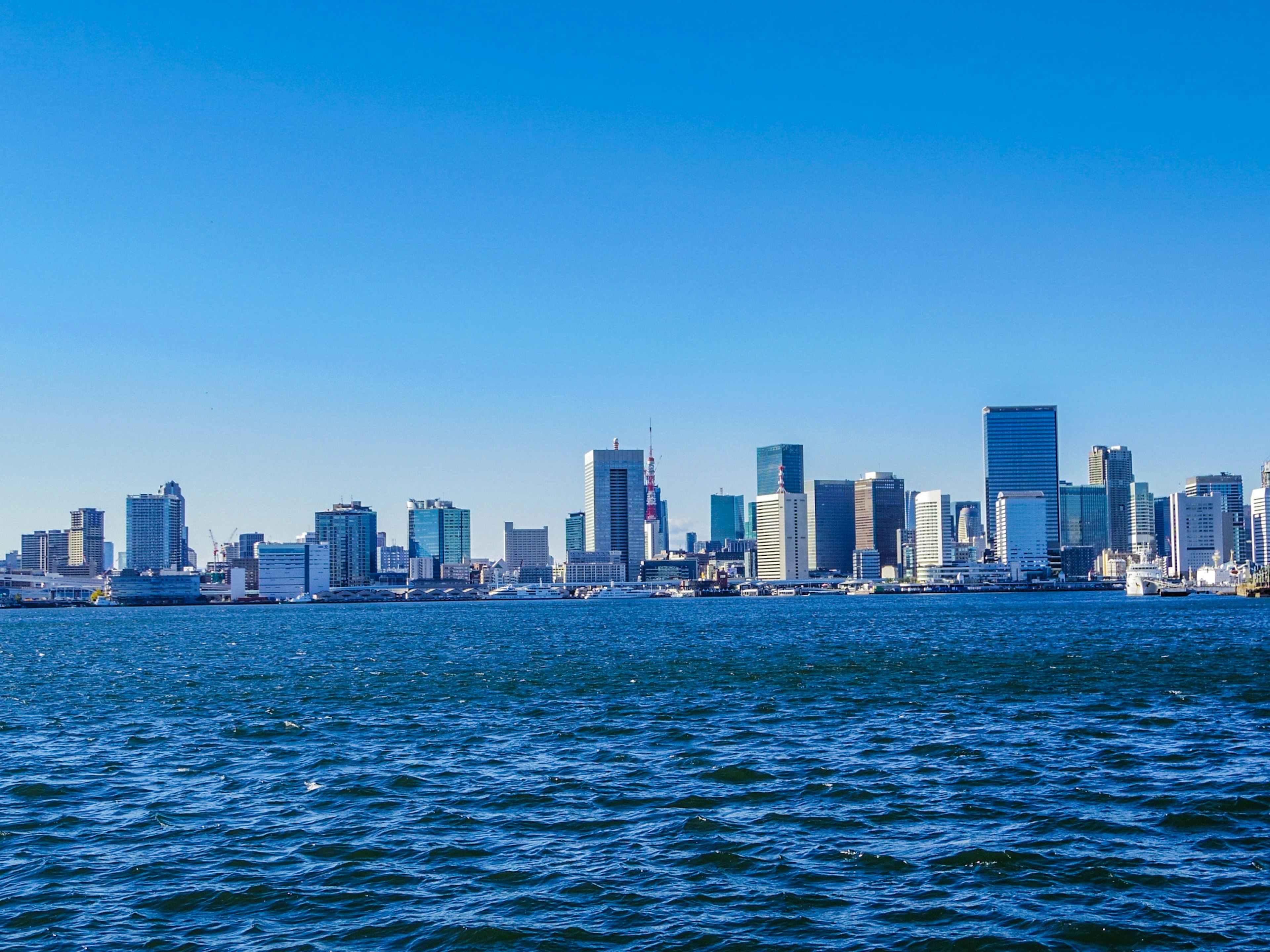 City skyline under a blue sky with calm waters