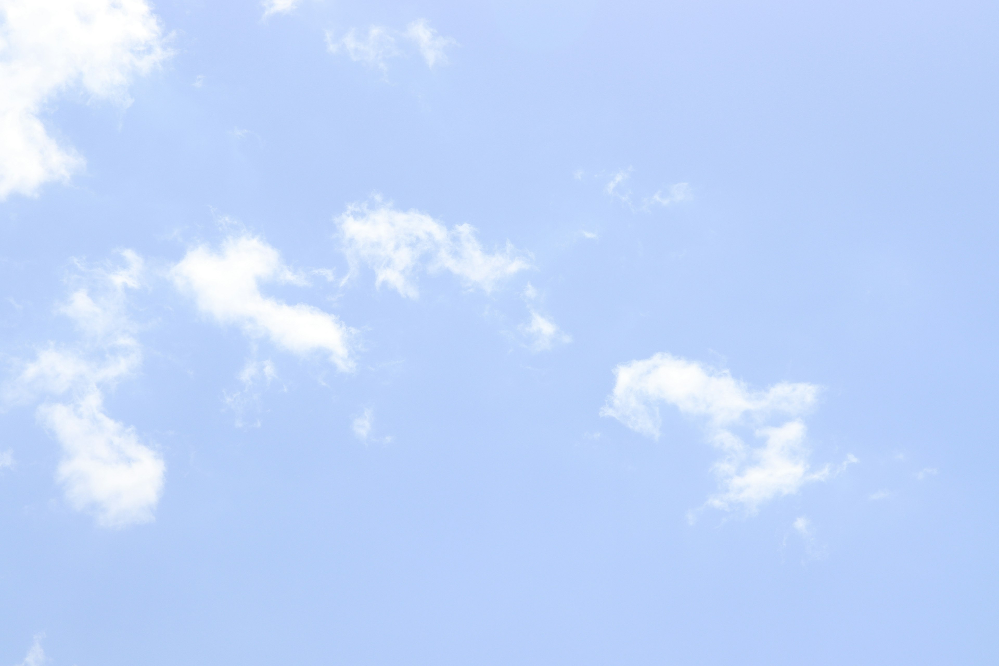 Ein klarer blauer Himmel mit verstreuten weißen Wolken