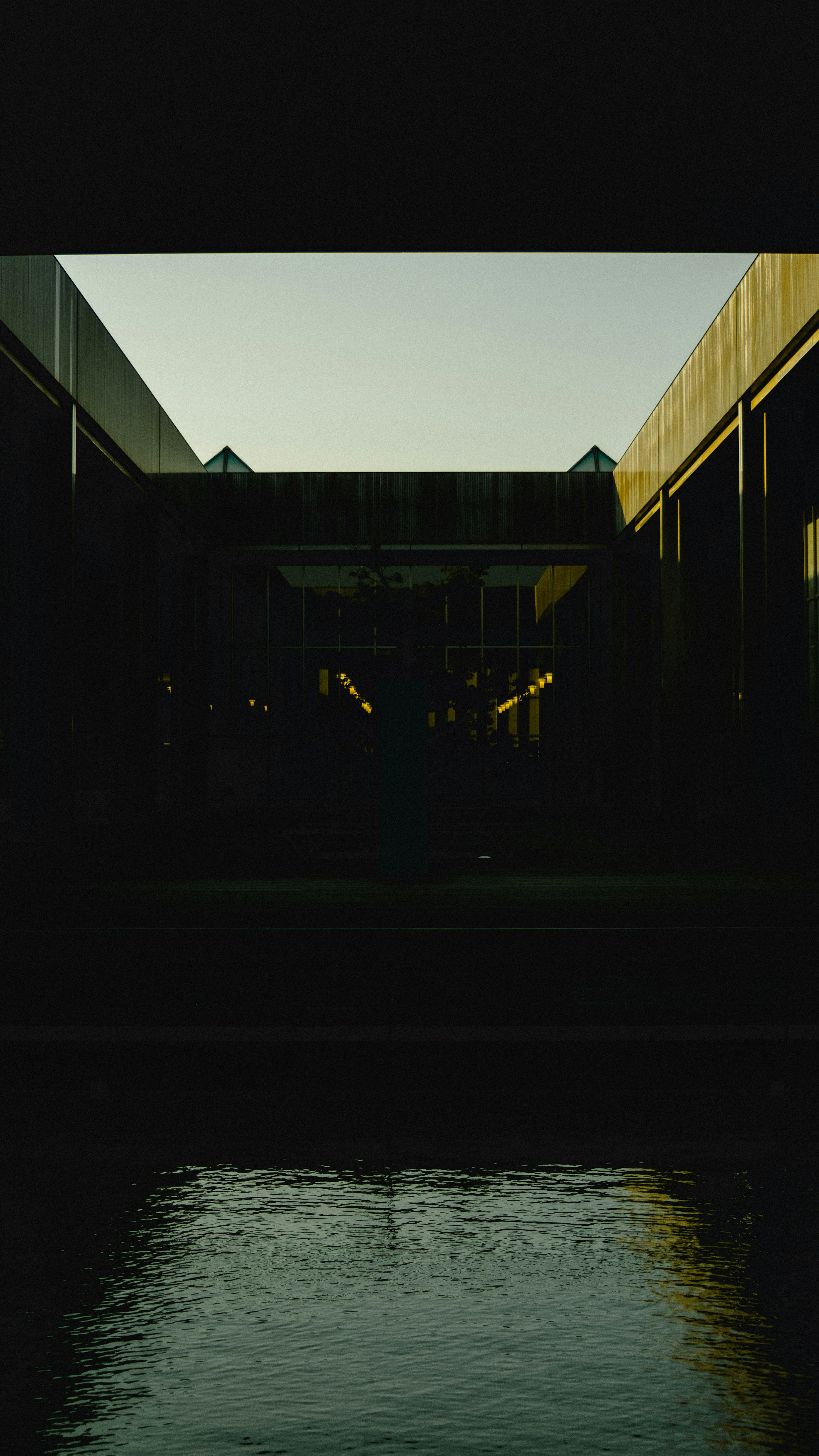 Silhouette of buildings and water surface in a dark space