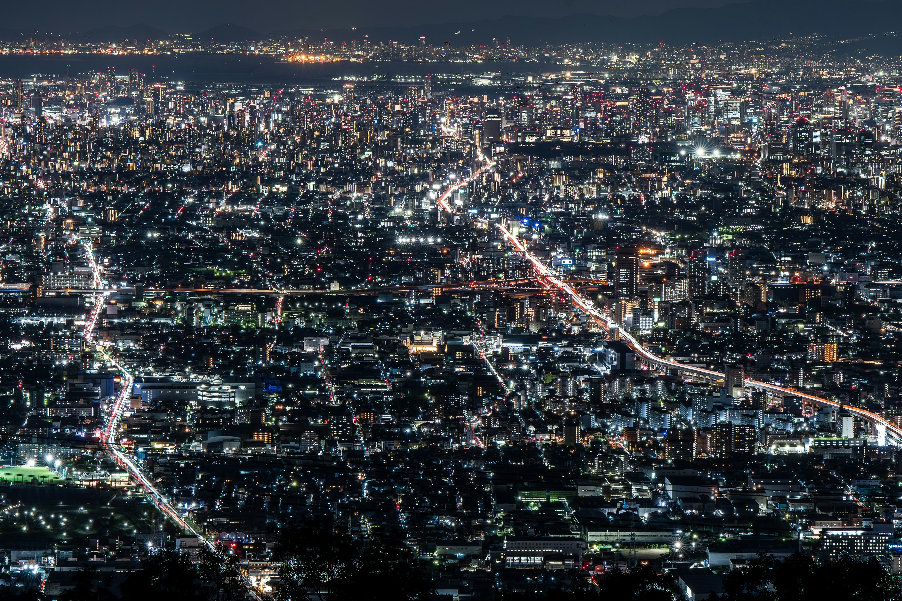 Vista nocturna de una ciudad extensa con calles iluminadas