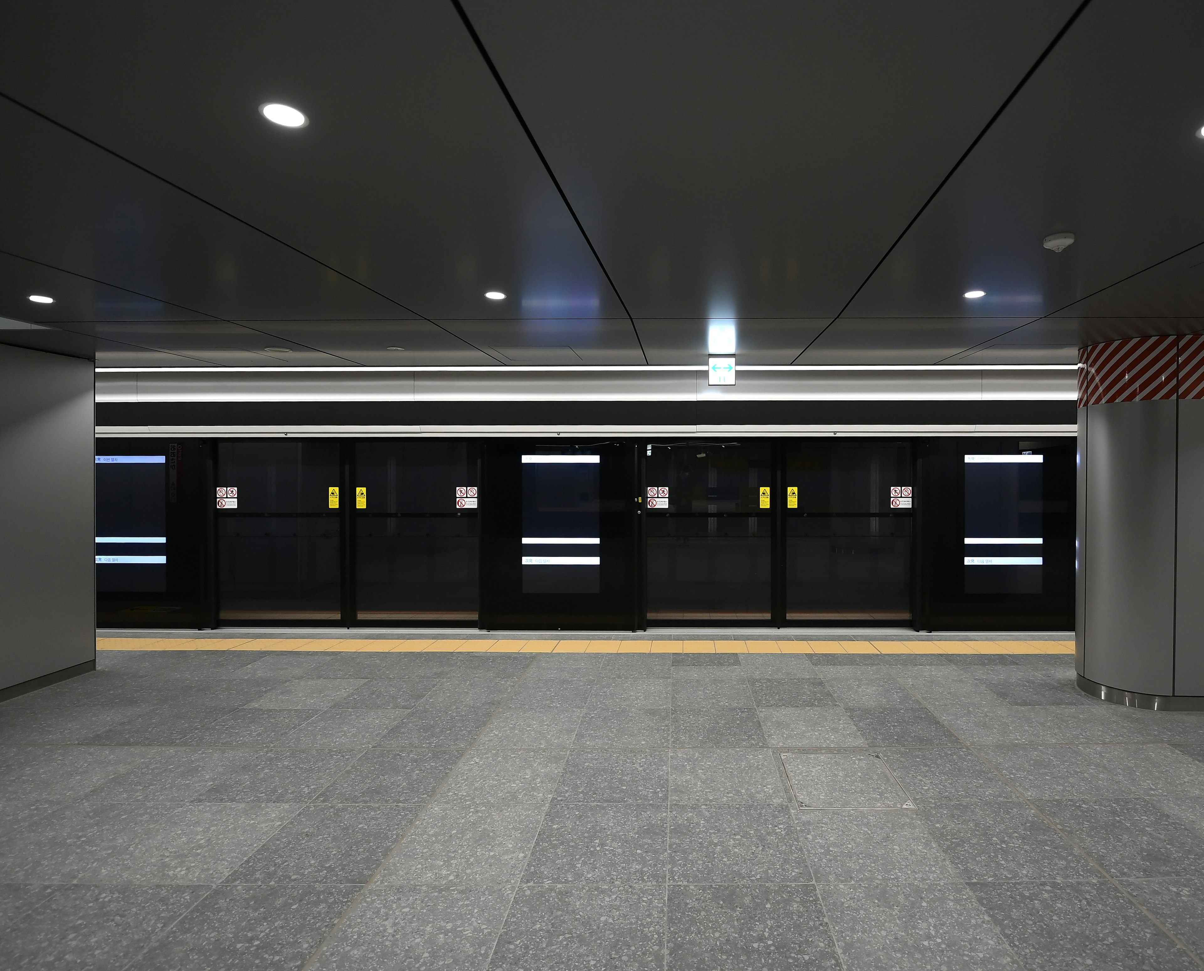 Plataforma de estación de metro con puertas de tren negras y buena iluminación