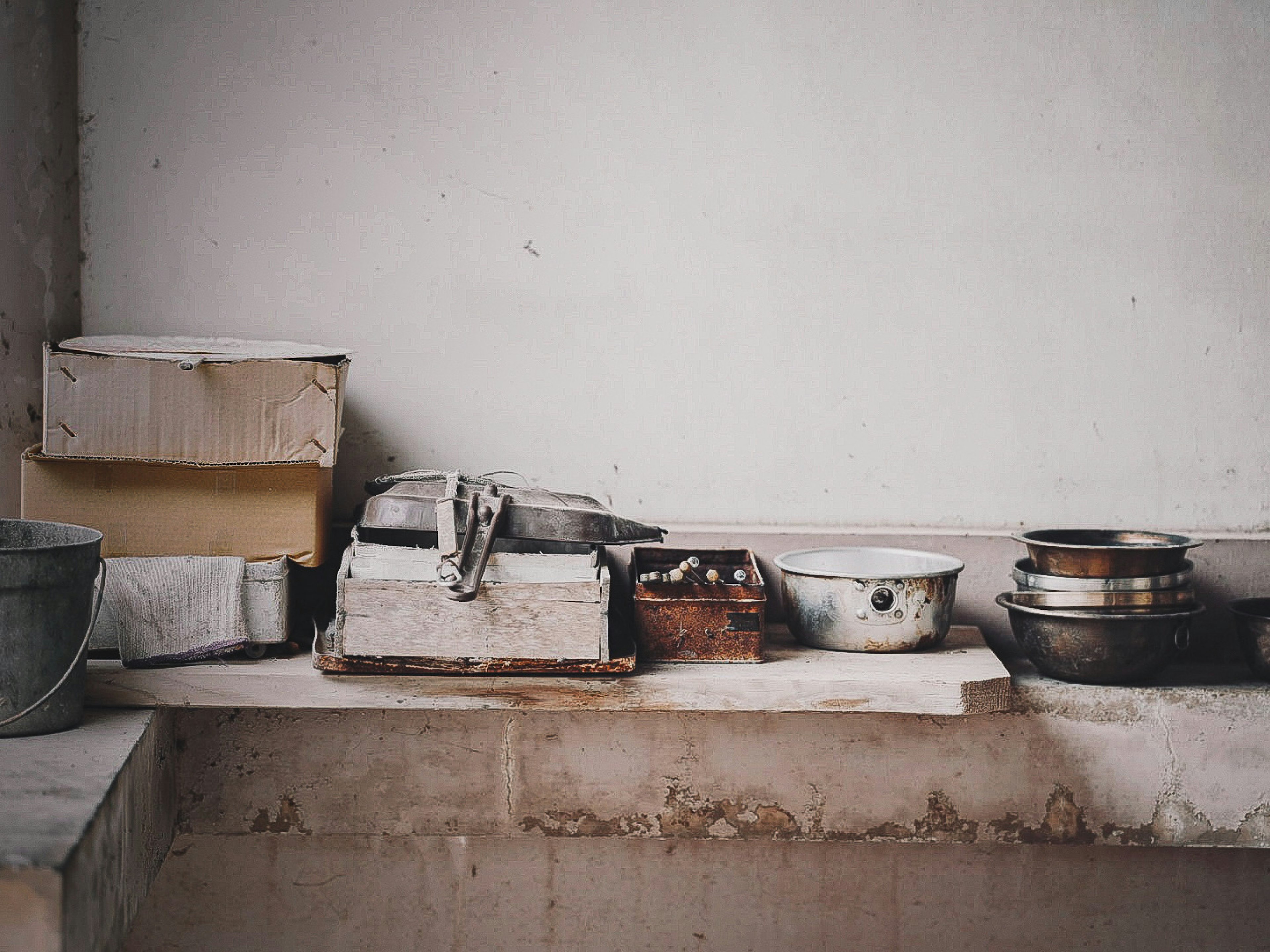 Una estantería de cocina simple que exhibe utensilios de cocina vintage y cajas