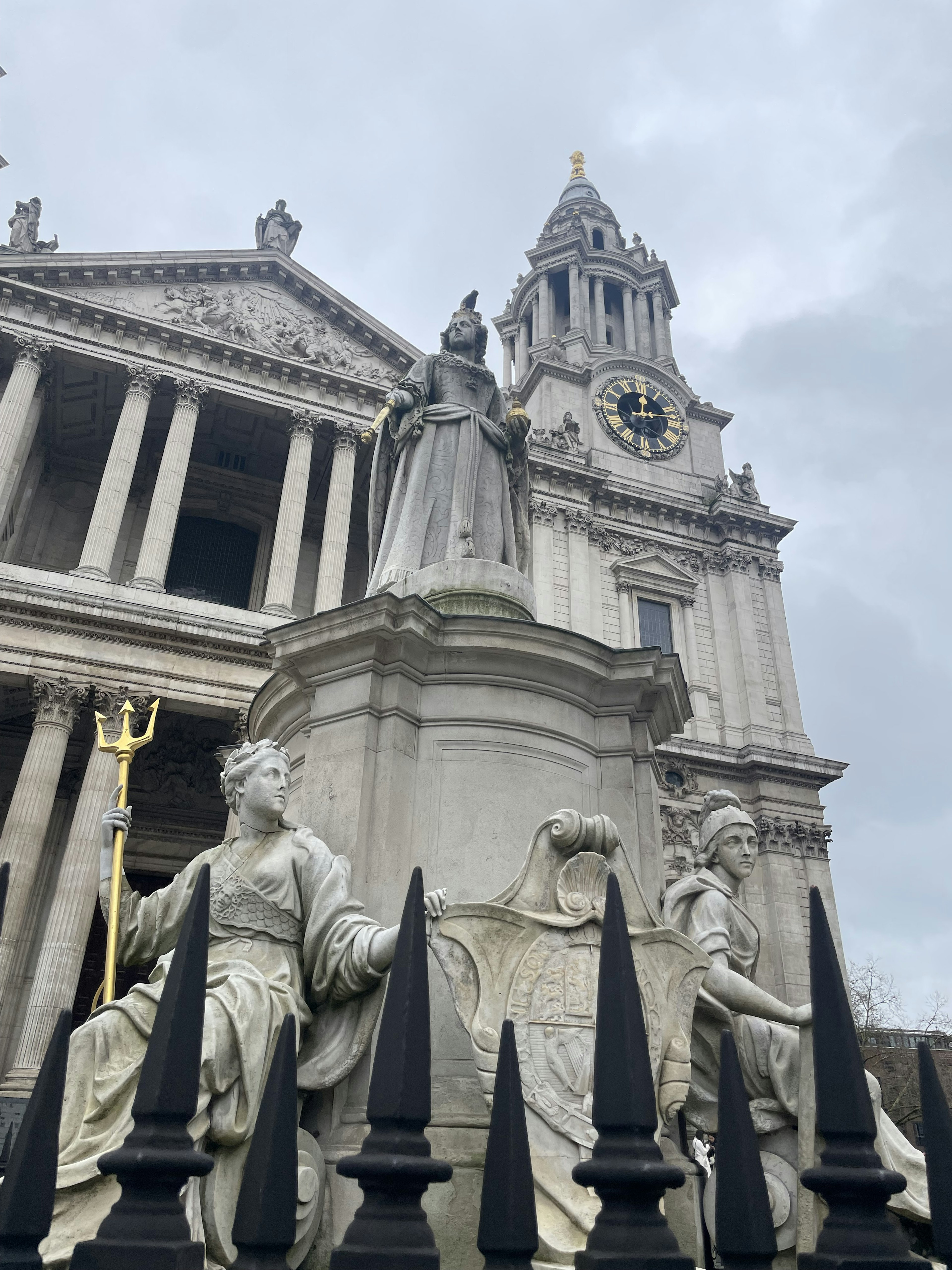 Patung di depan Katedral St Paul dengan menara jam