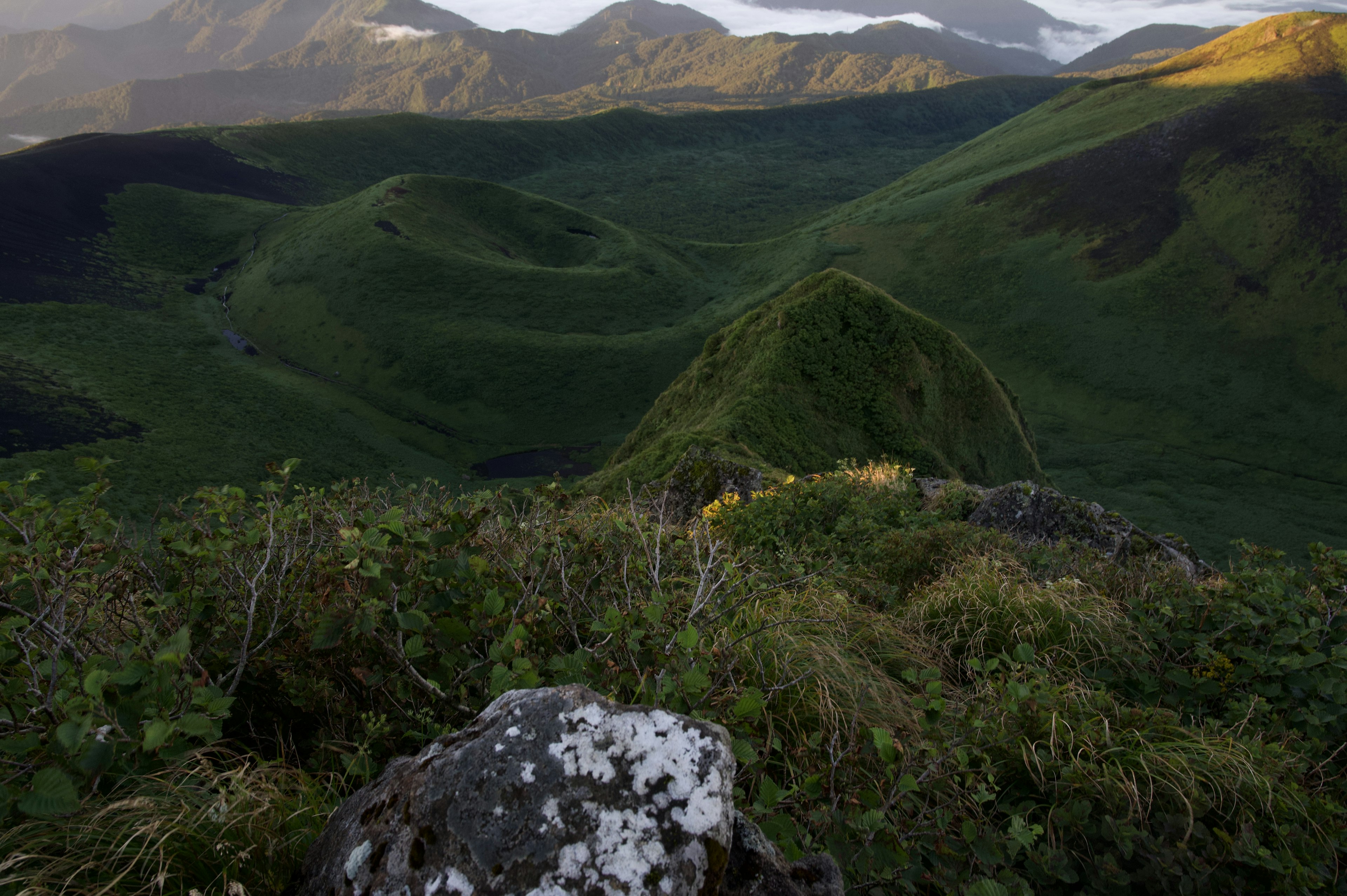 緑の丘陵と岩の風景が広がる山の景色