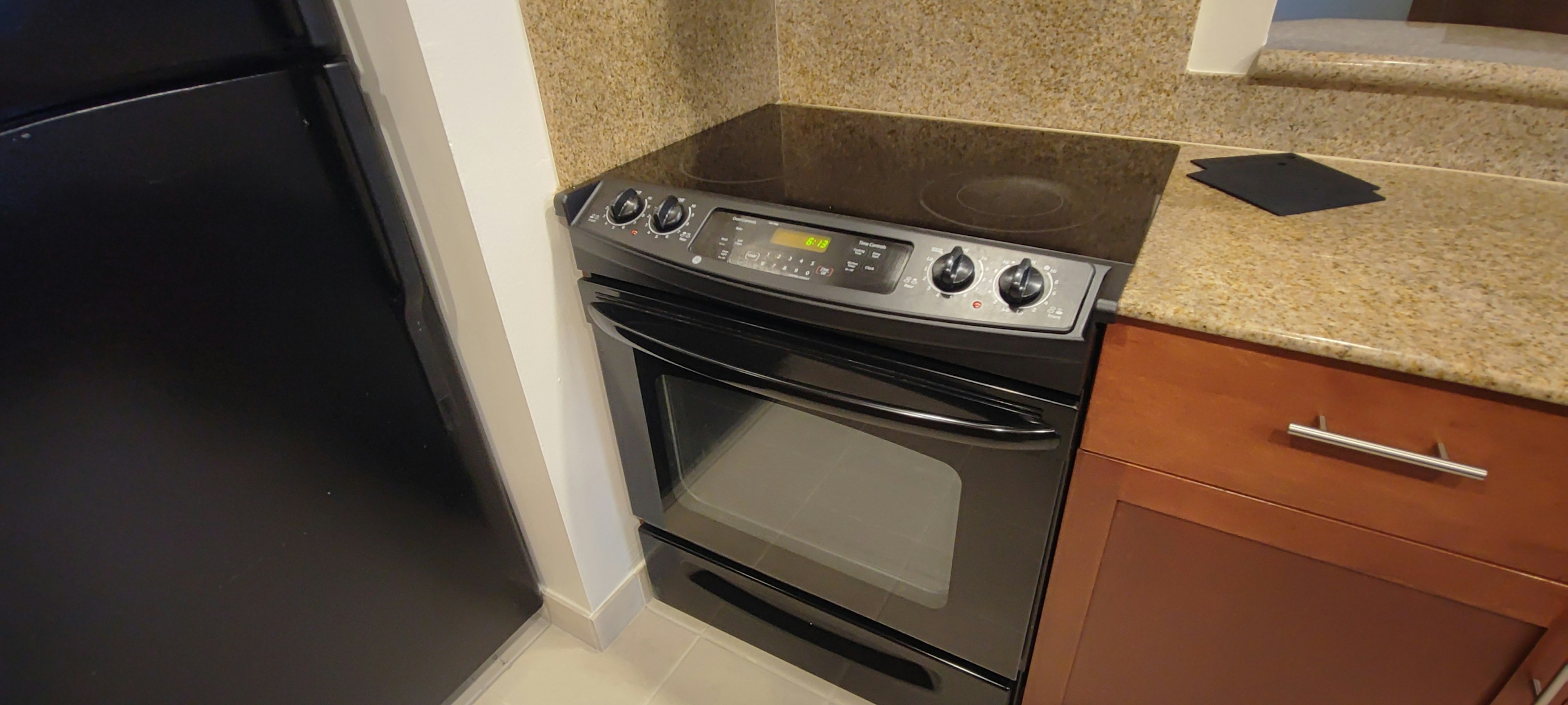 Black oven installed in a kitchen with granite countertop