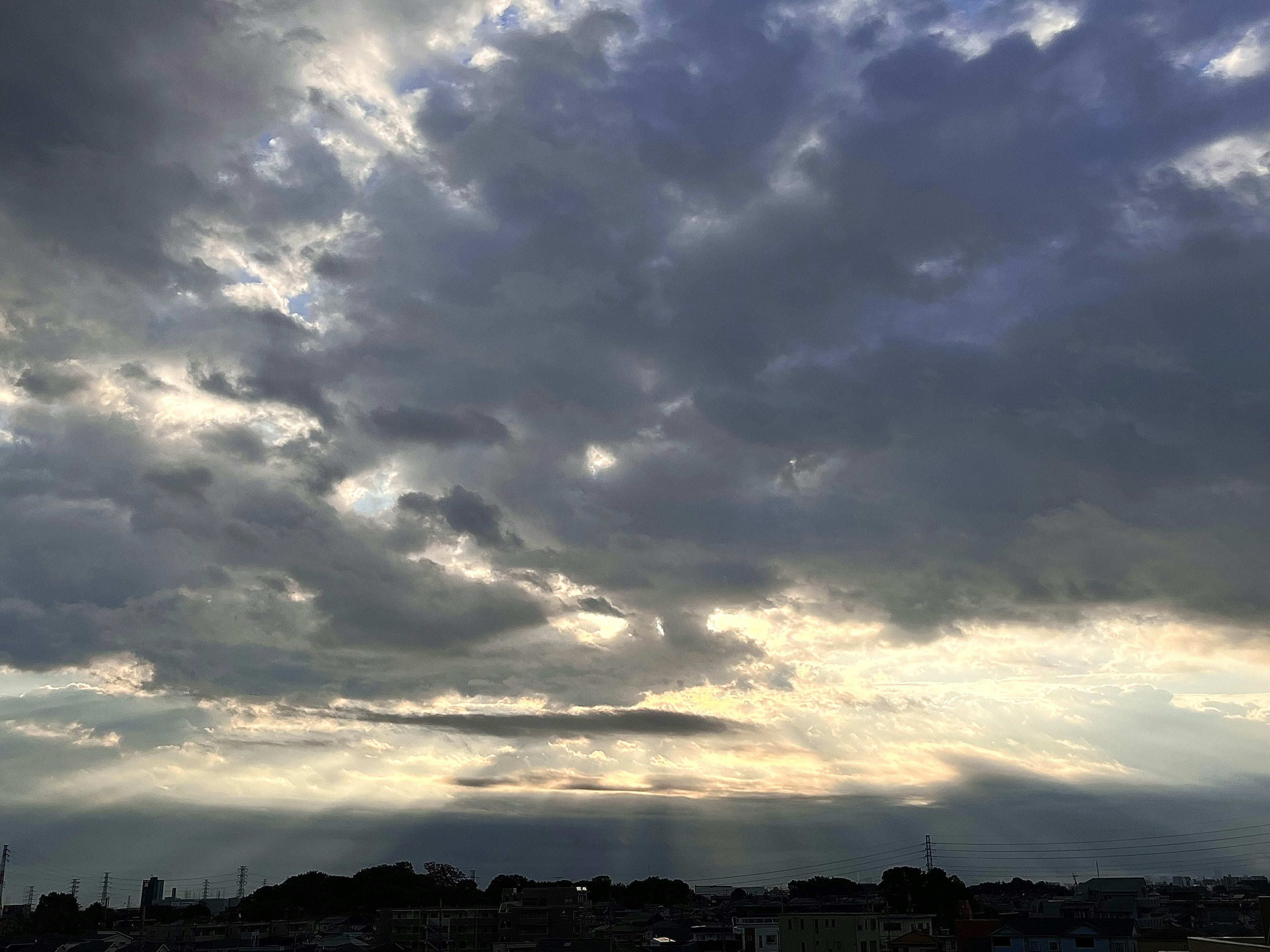 Langit dramatis dengan awan dan sinar matahari saat matahari terbenam