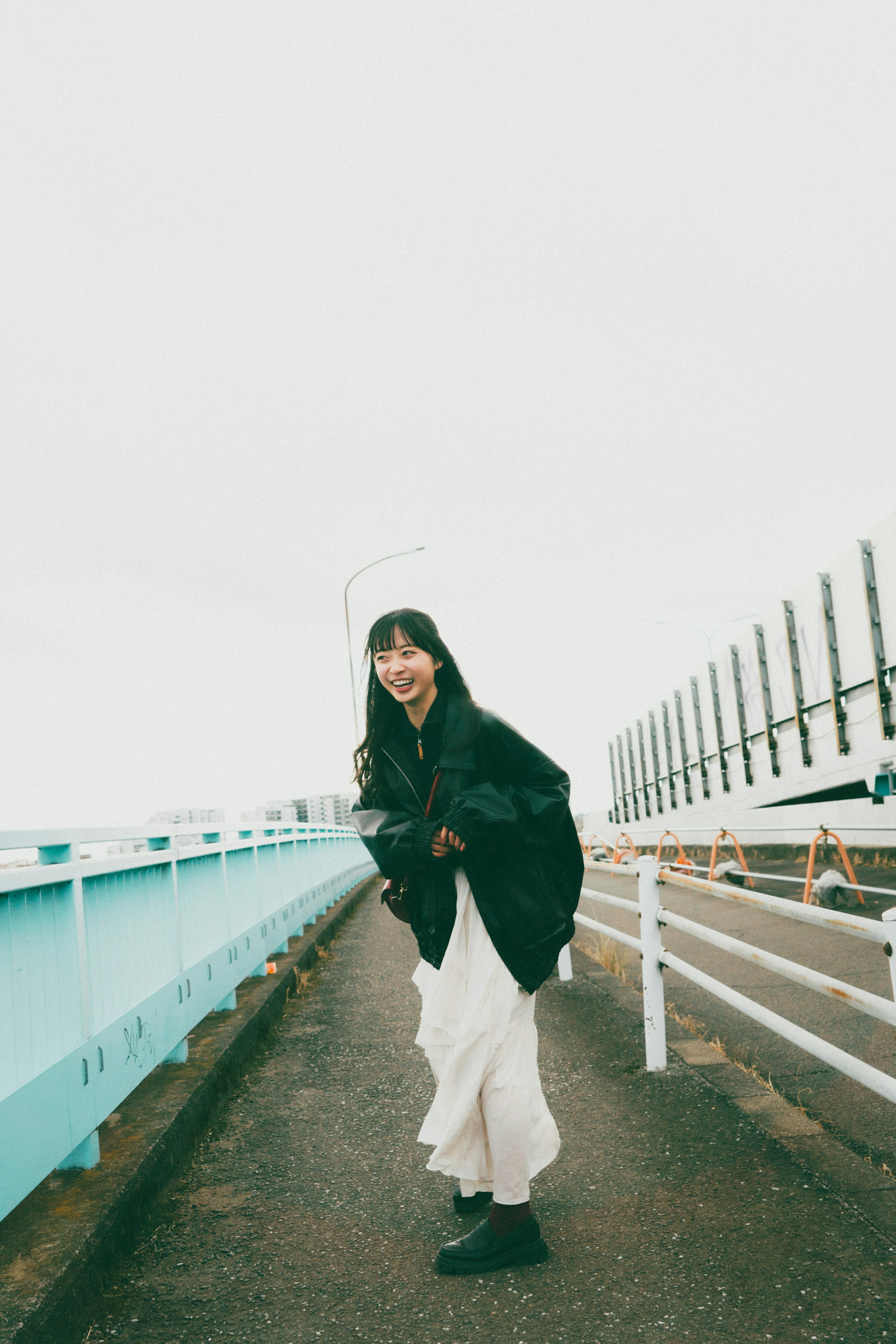 Une femme souriante debout sur un pont