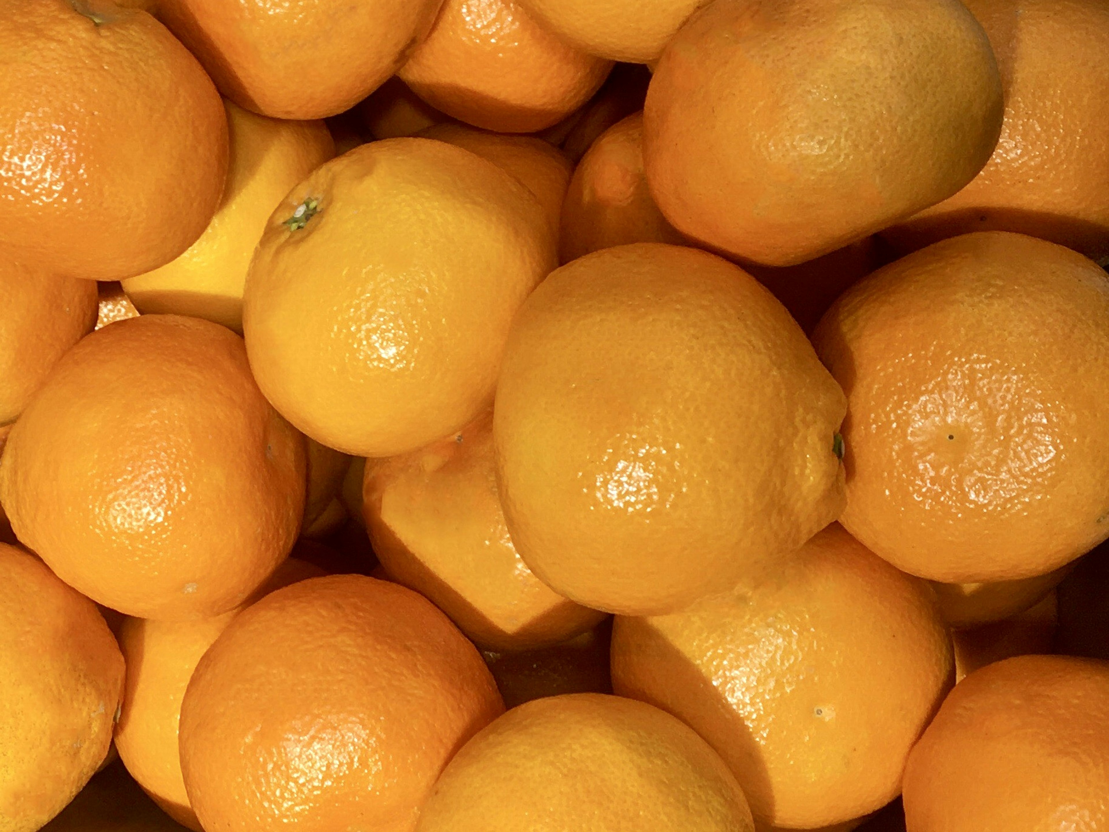 A pile of fresh oranges stacked together