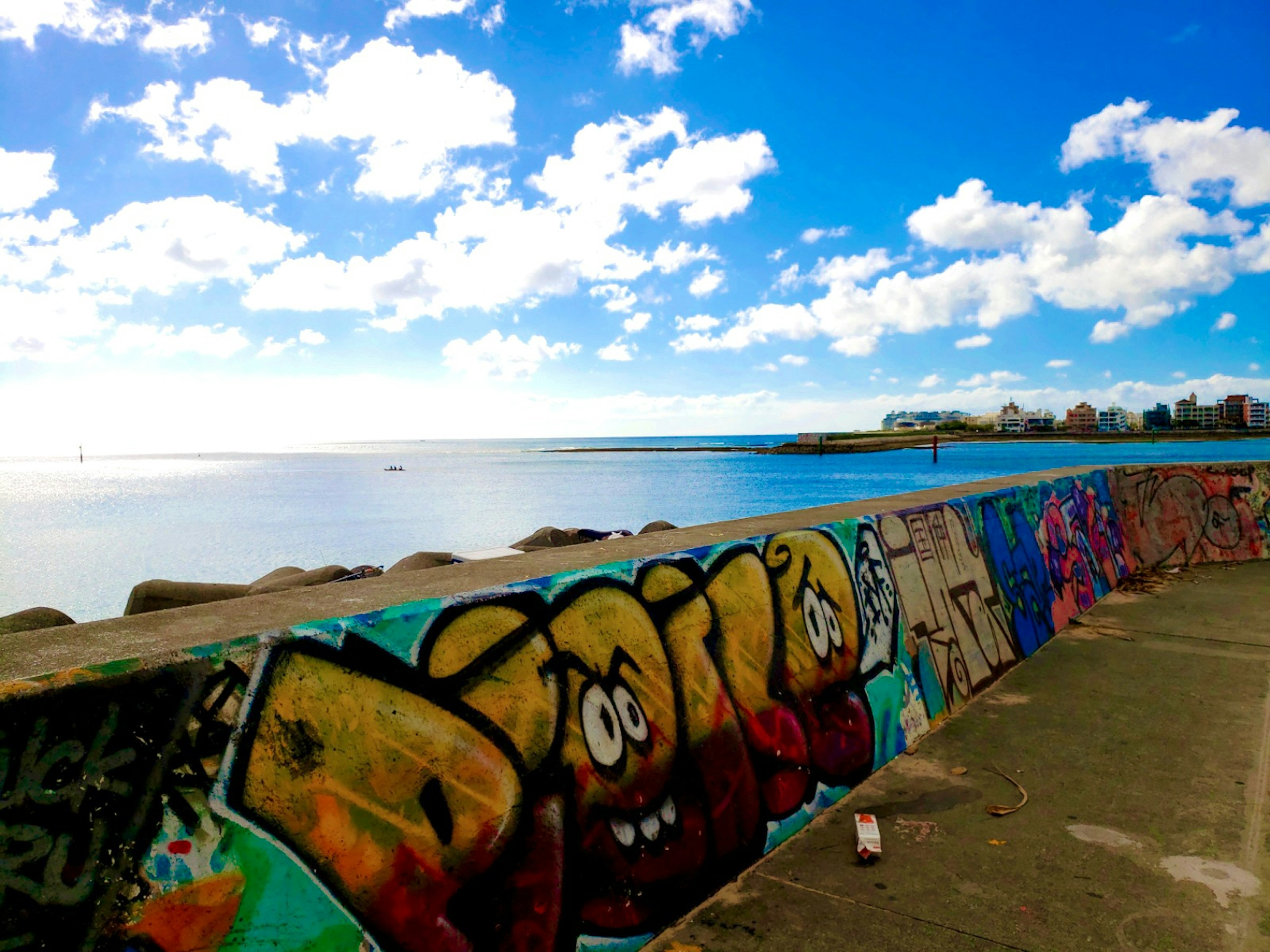 Bunter Graffiti-Wall mit blauem Himmel und Meer im Hintergrund