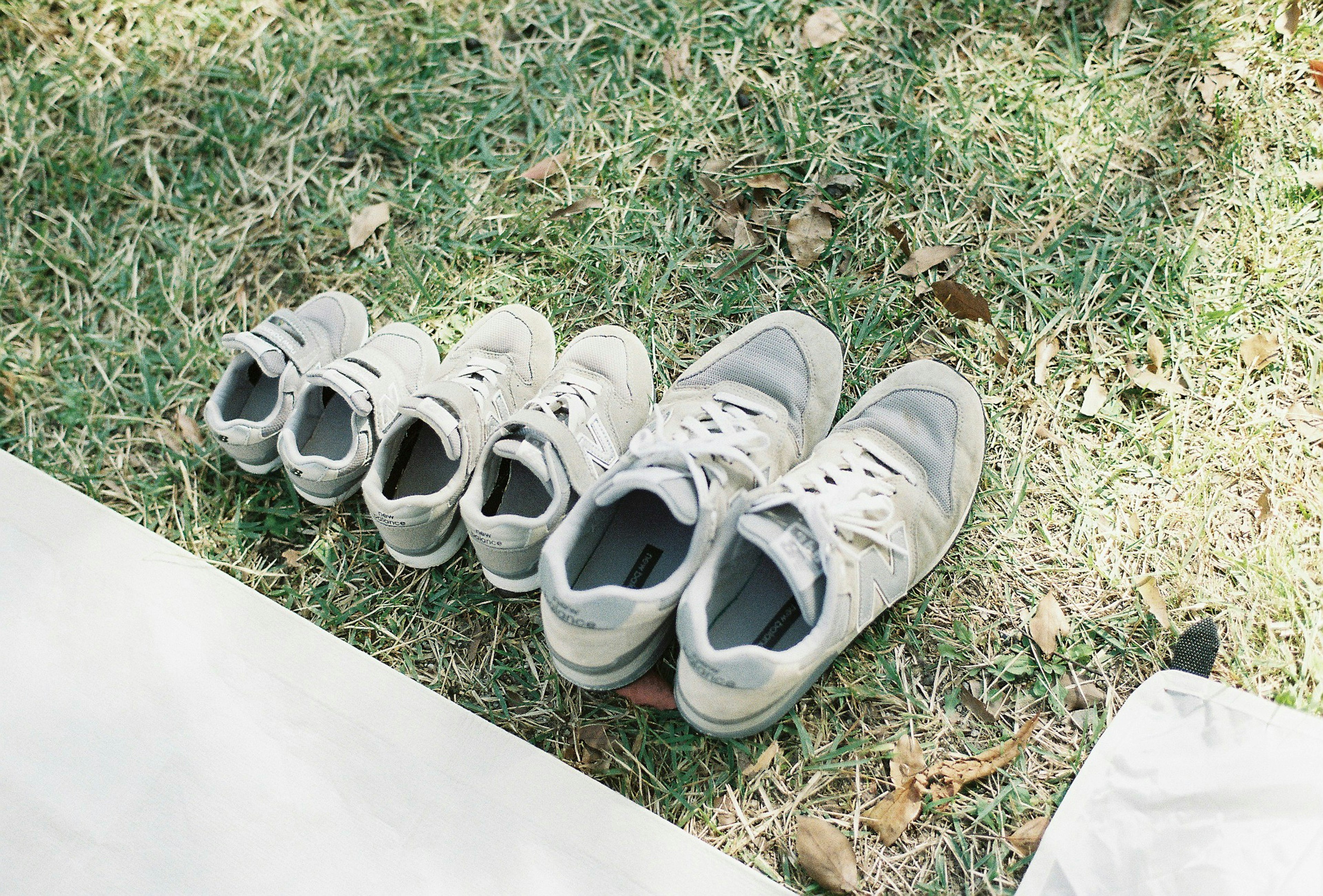 Différentes tailles de baskets disposées soigneusement sur l'herbe