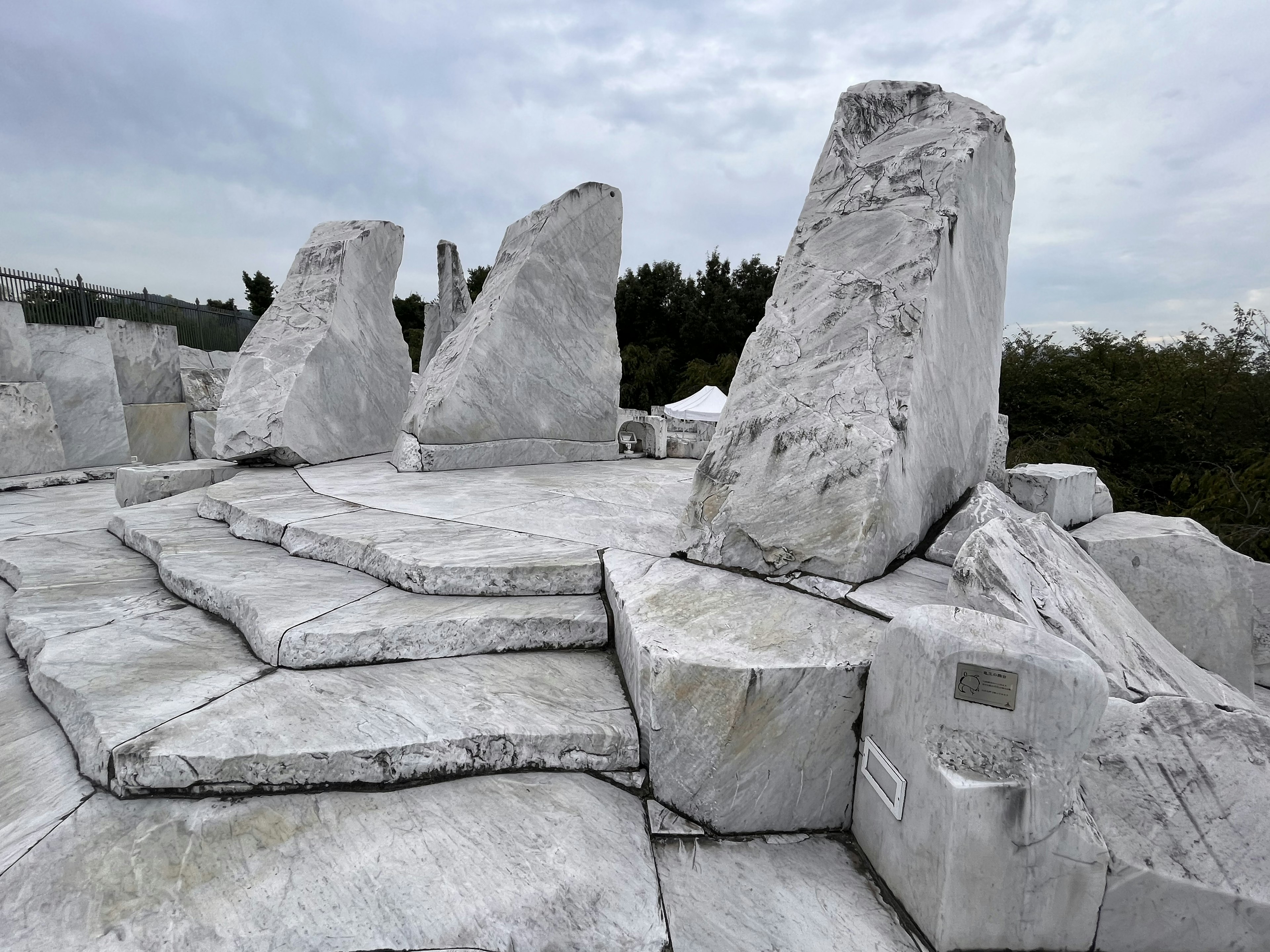 Außenlandschaft mit weißen Marmorskulpturen und Steinstufen