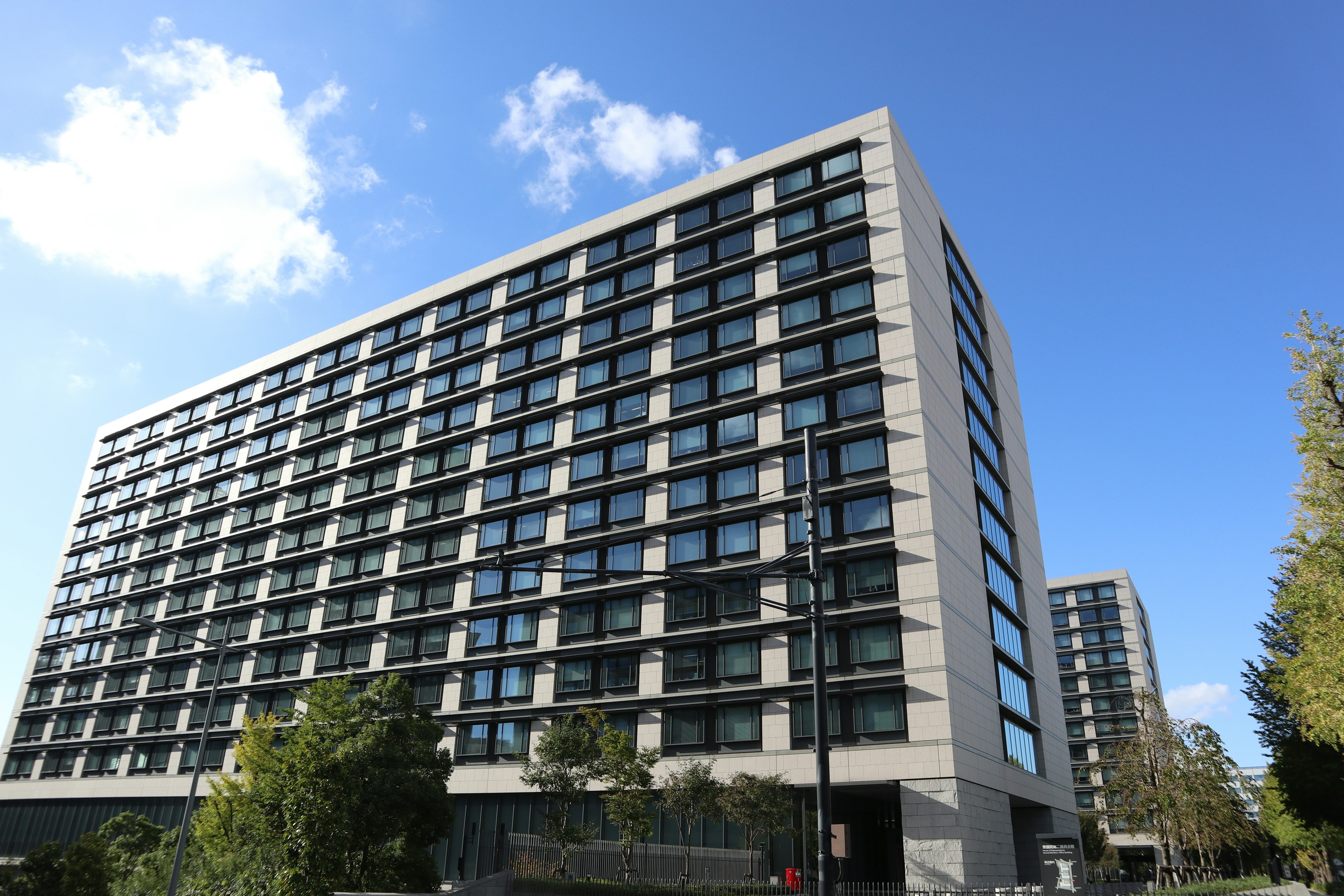 Modern residential building exterior with blue sky and clouds