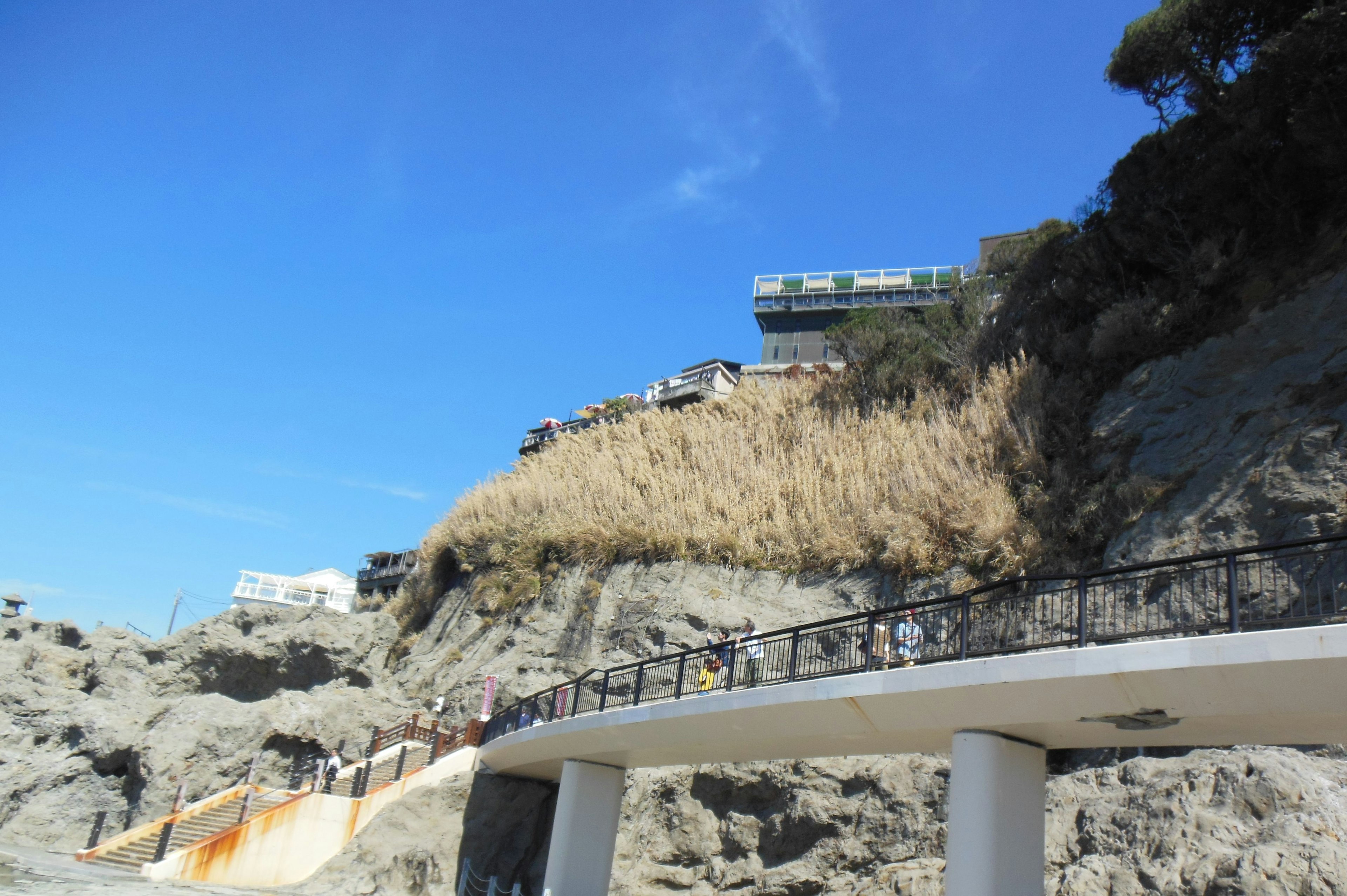 Vue pittoresque d'une promenade côtière avec un bâtiment sur une falaise en arrière-plan