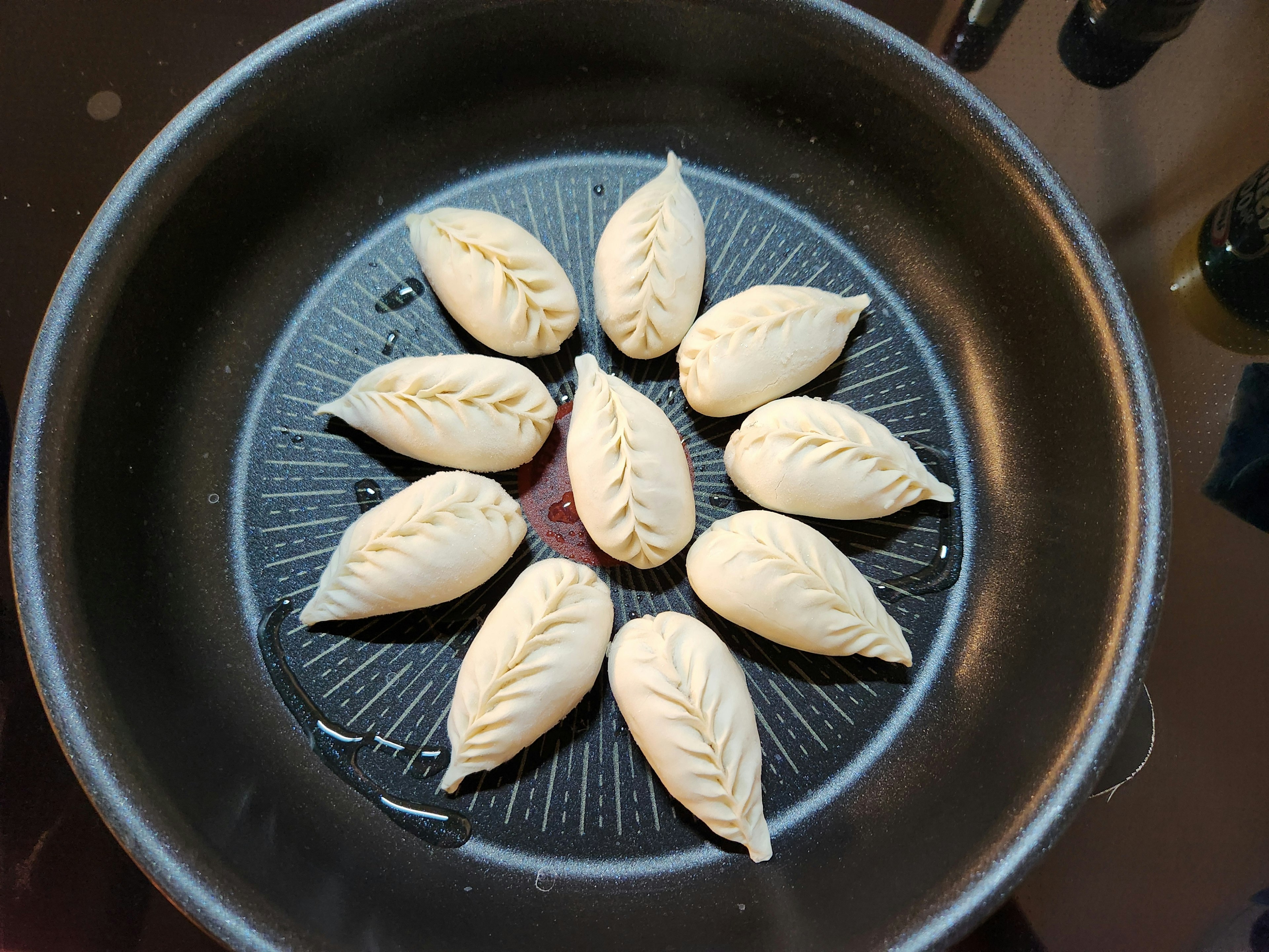 Dough shaped like leaves arranged in a frying pan