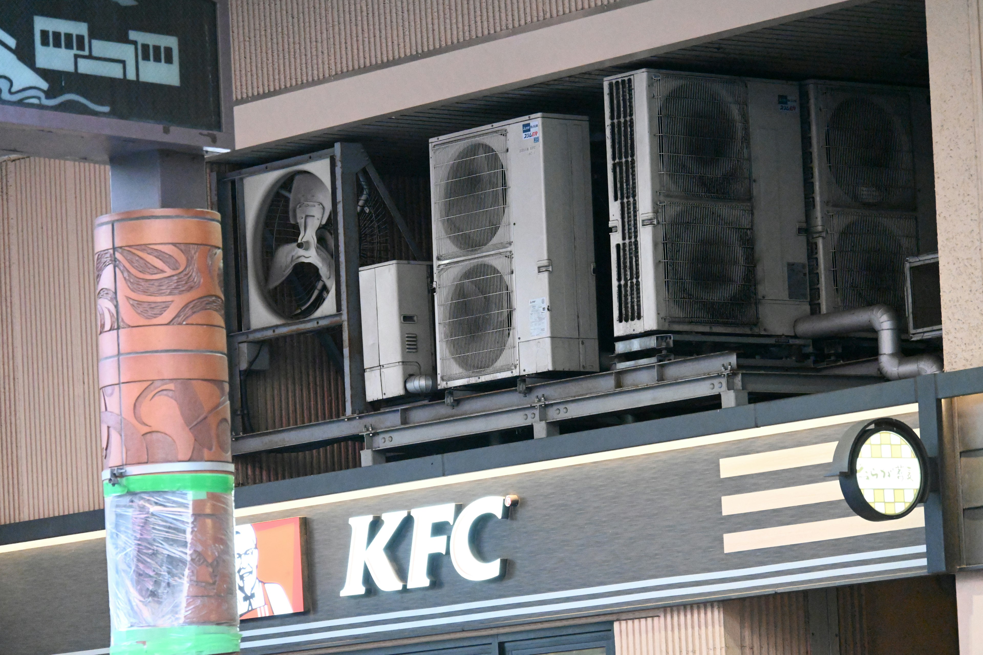 Imagen de unidades de aire acondicionado instaladas sobre un letrero de KFC