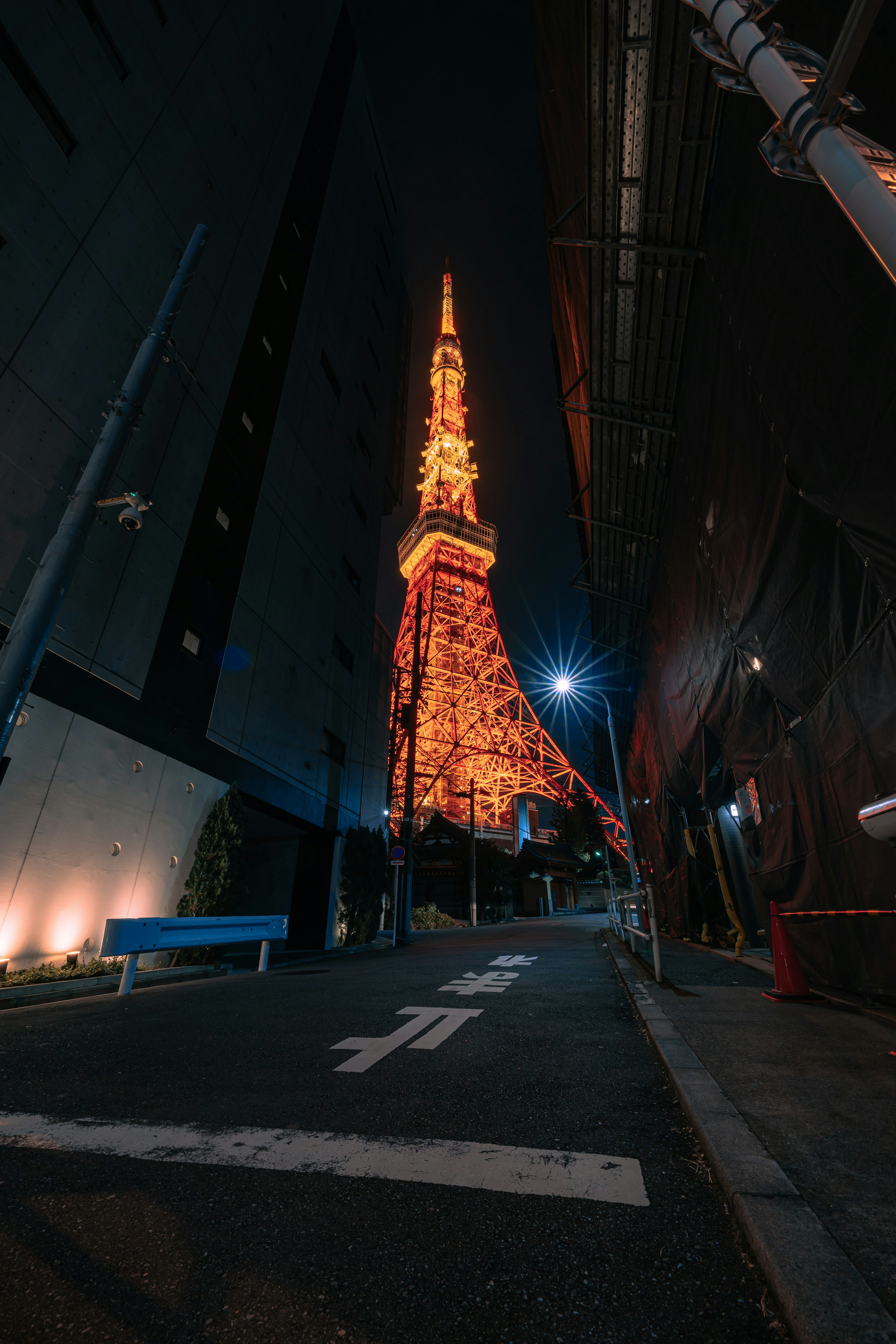 Tokyo Tower illuminated at night in a narrow street