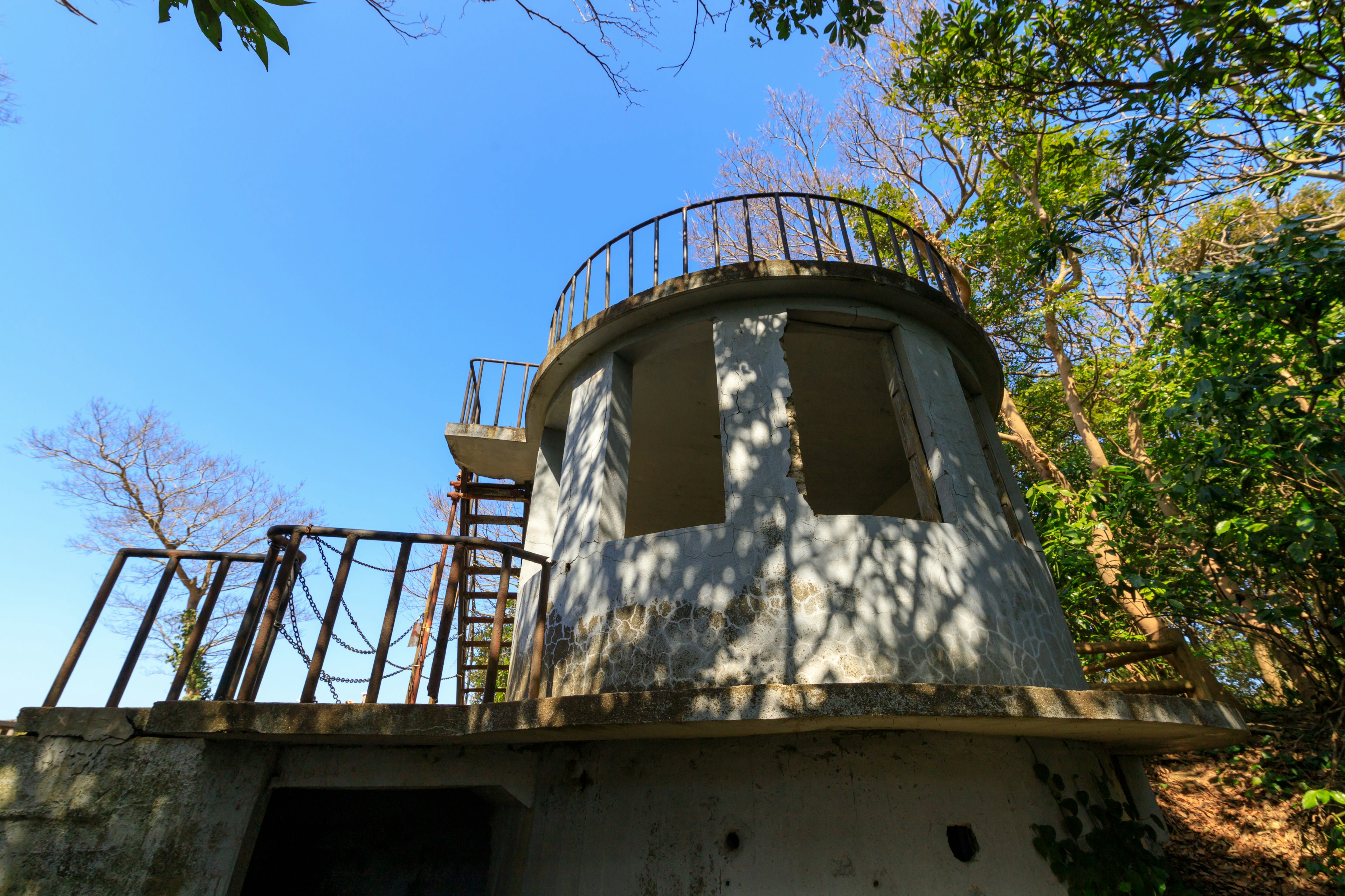 Außenansicht eines baufälligen Turms mit blauem Himmel im Hintergrund