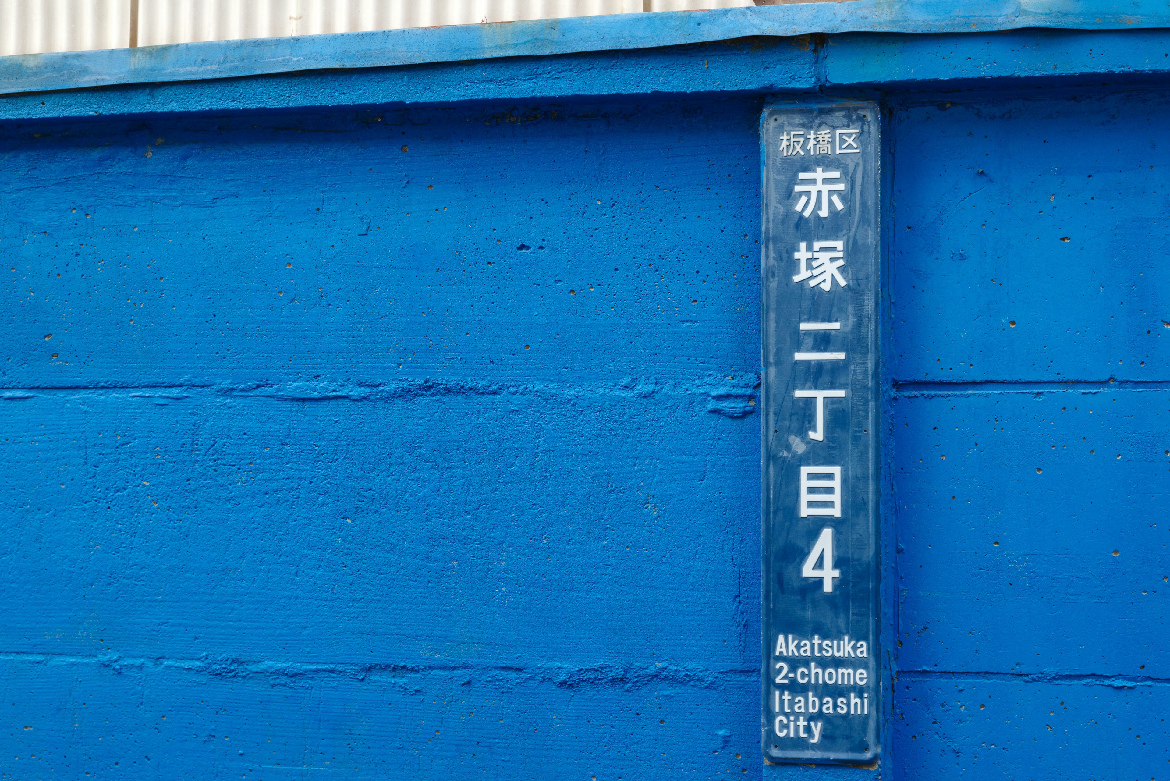 Address sign for Akasaka 2-chome 4 displayed on a blue wall