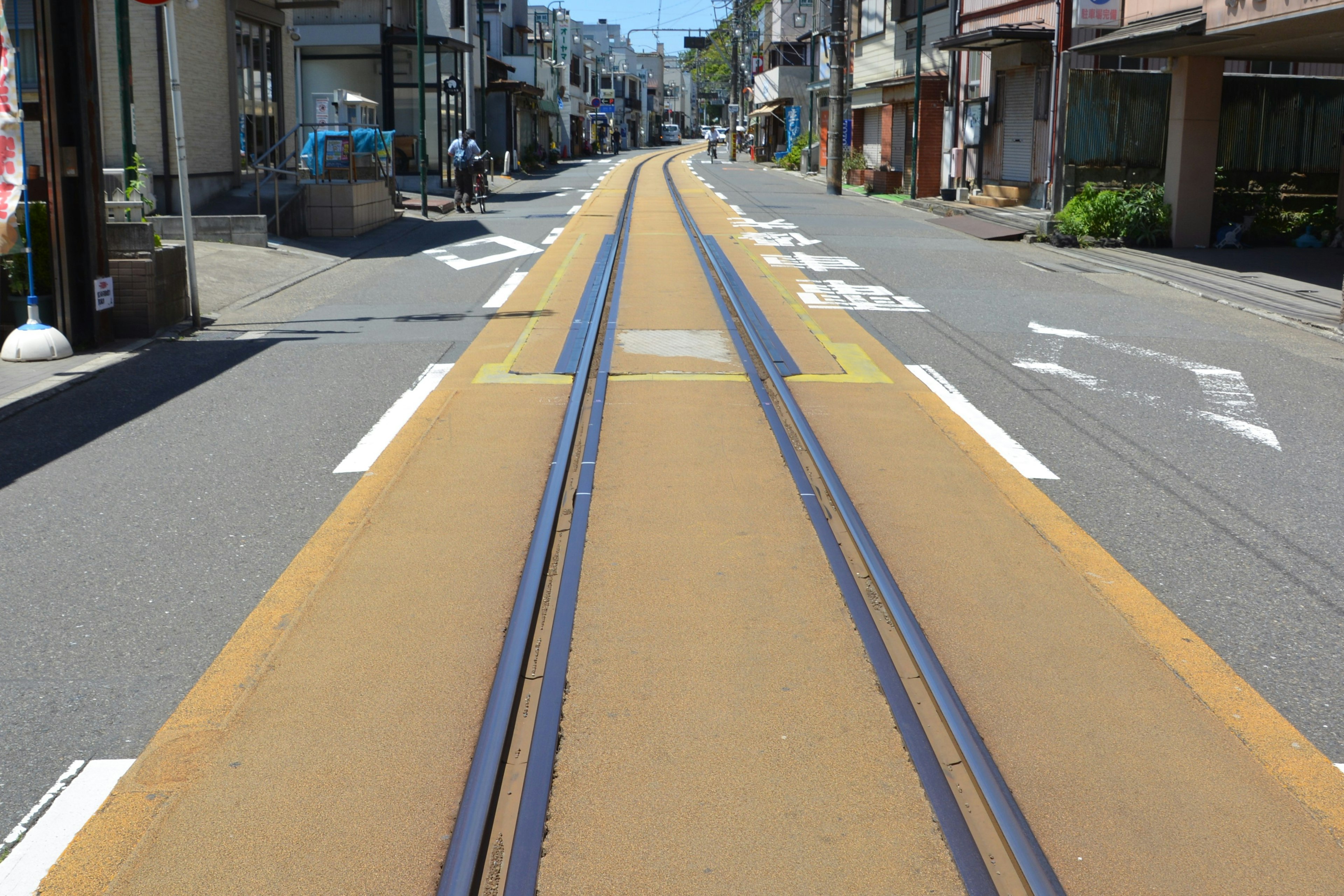 A quiet street with yellow tram tracks running through it