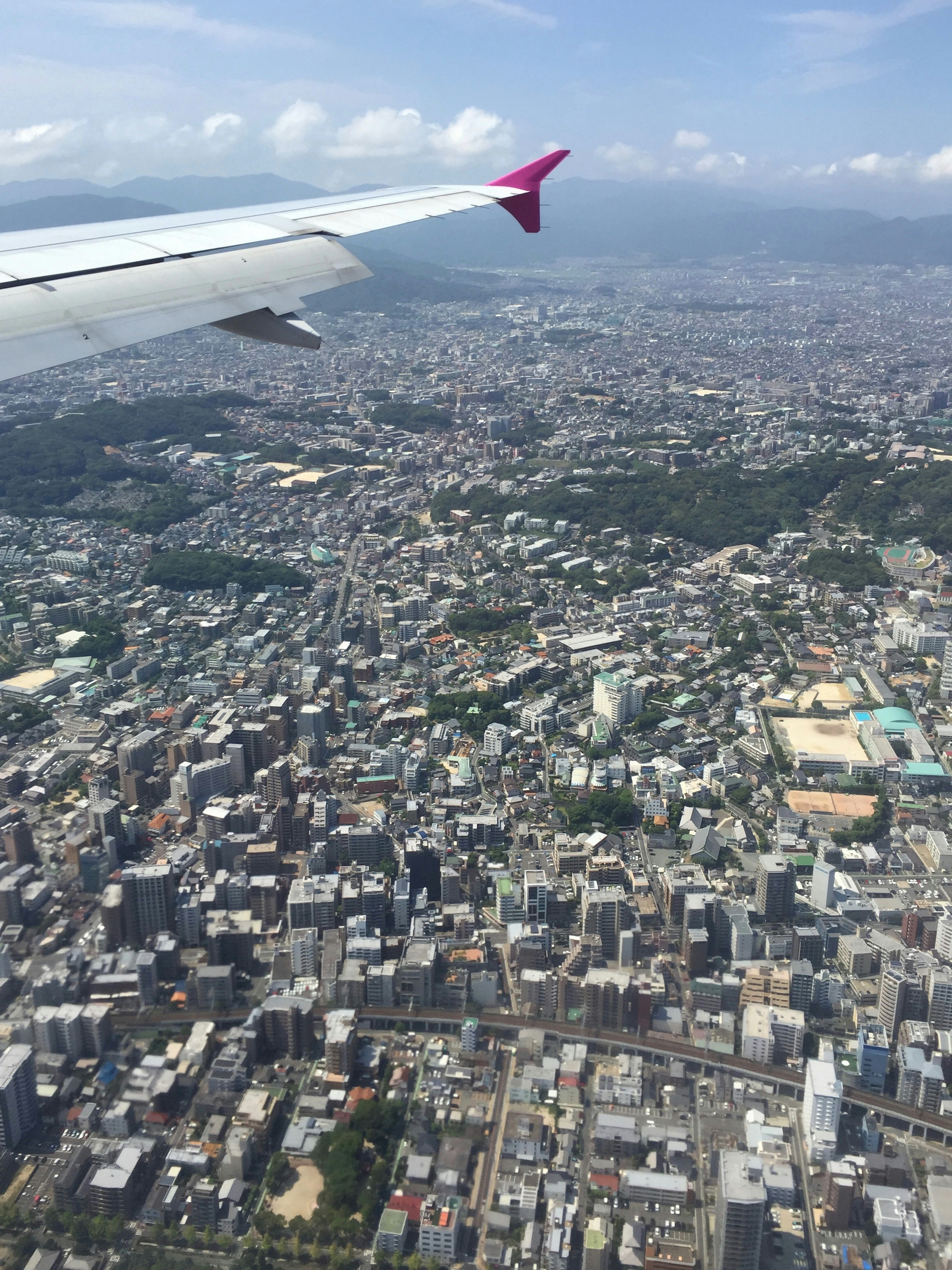 Aerial view of a city with an airplane wing