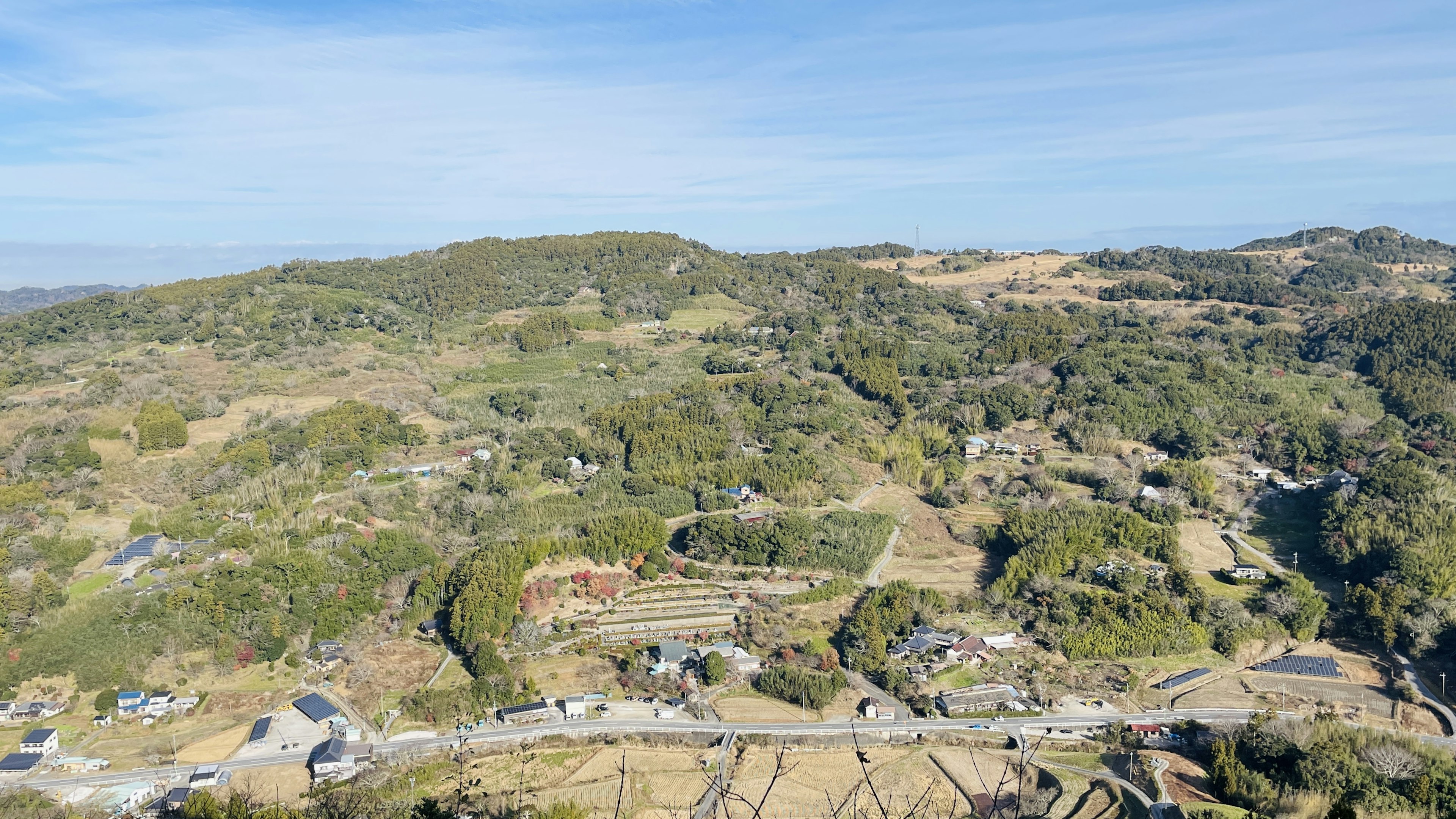 Vue aérienne de collines verdoyantes et de hameaux éparpillés