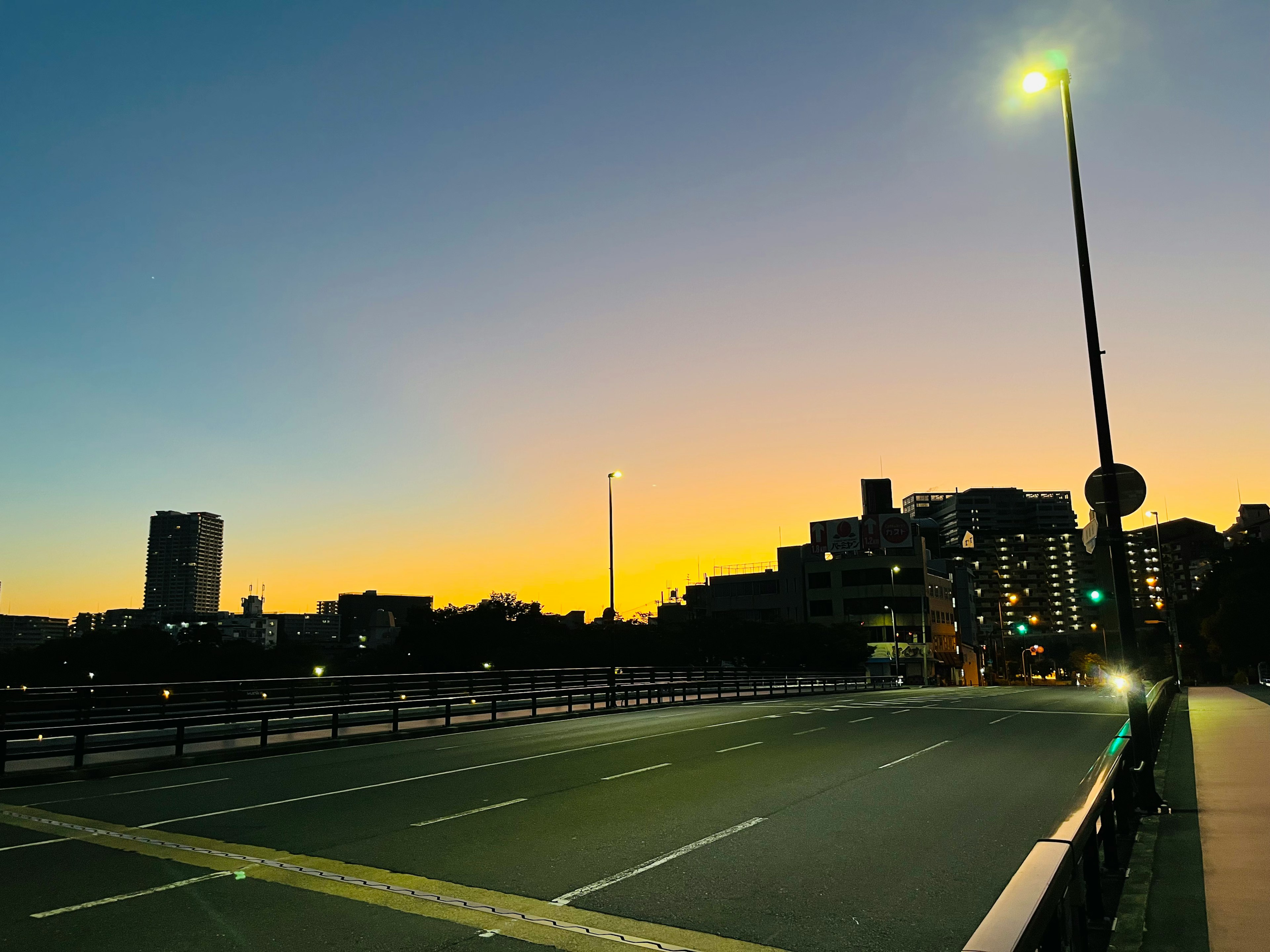 Cityscape at dusk with bright streetlights on a bridge