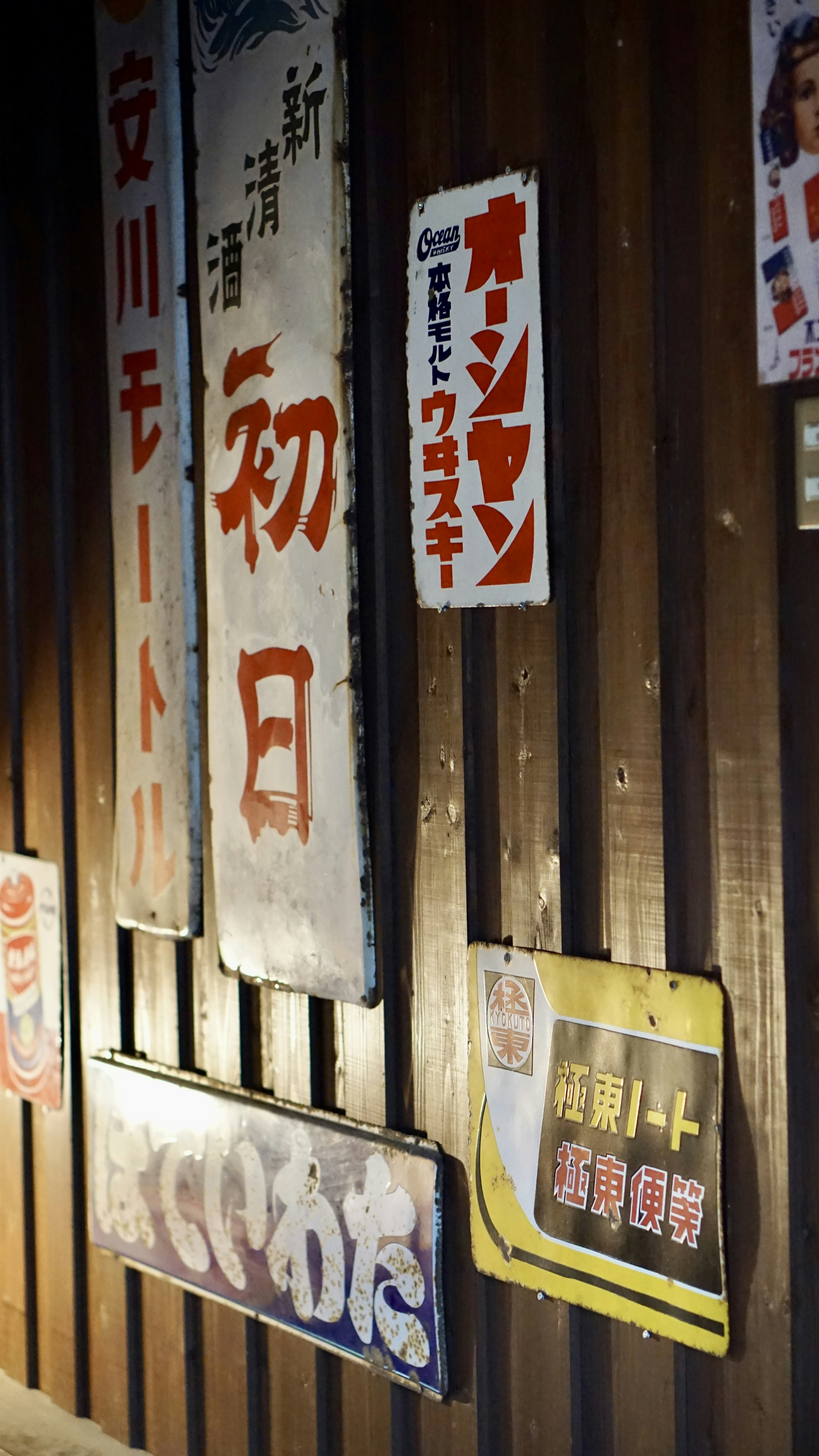 Old Japanese signs displayed on a wooden wall