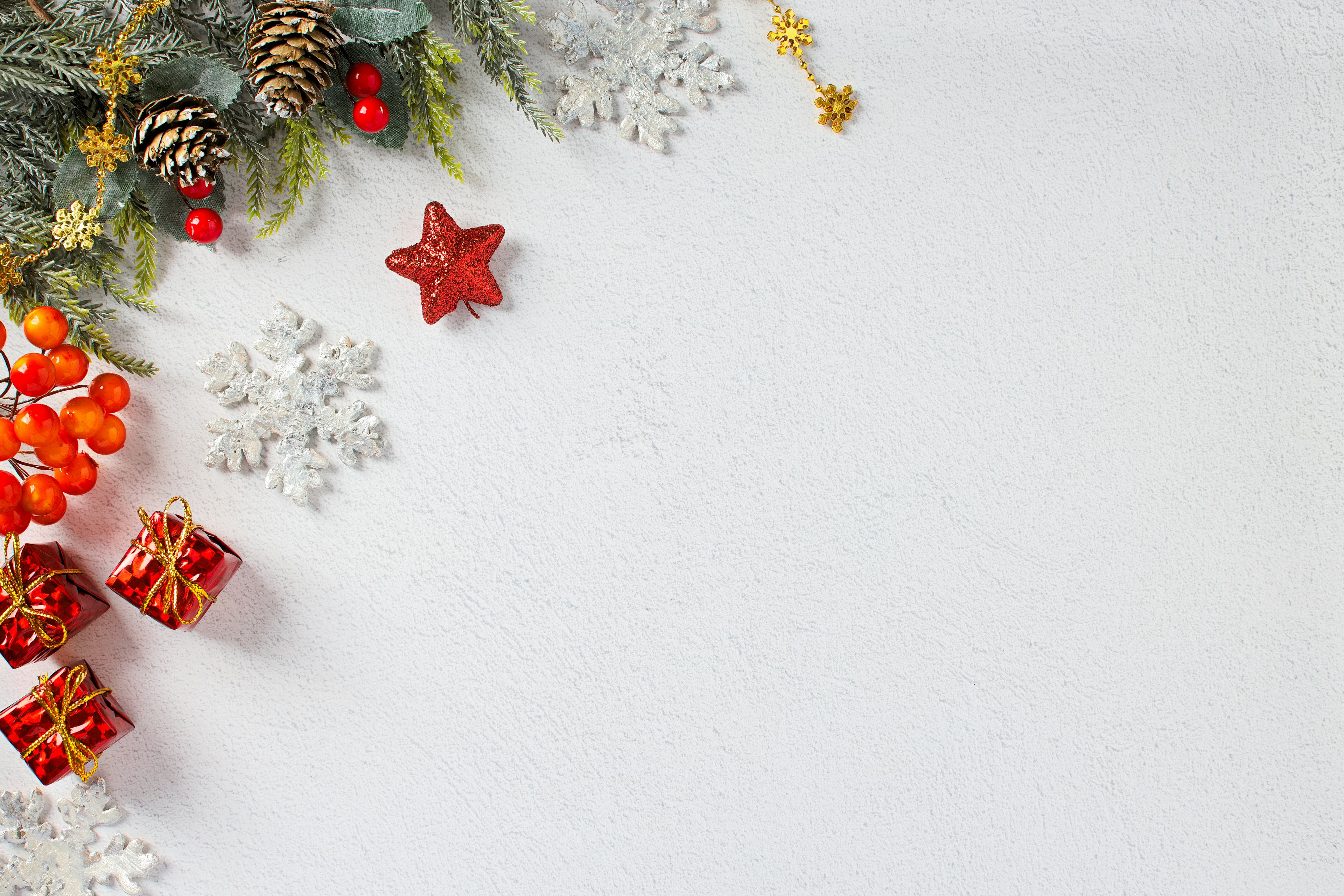 Decorazioni natalizie su uno sfondo bianco con scatole regalo rosse e fiocchi di neve sparsi