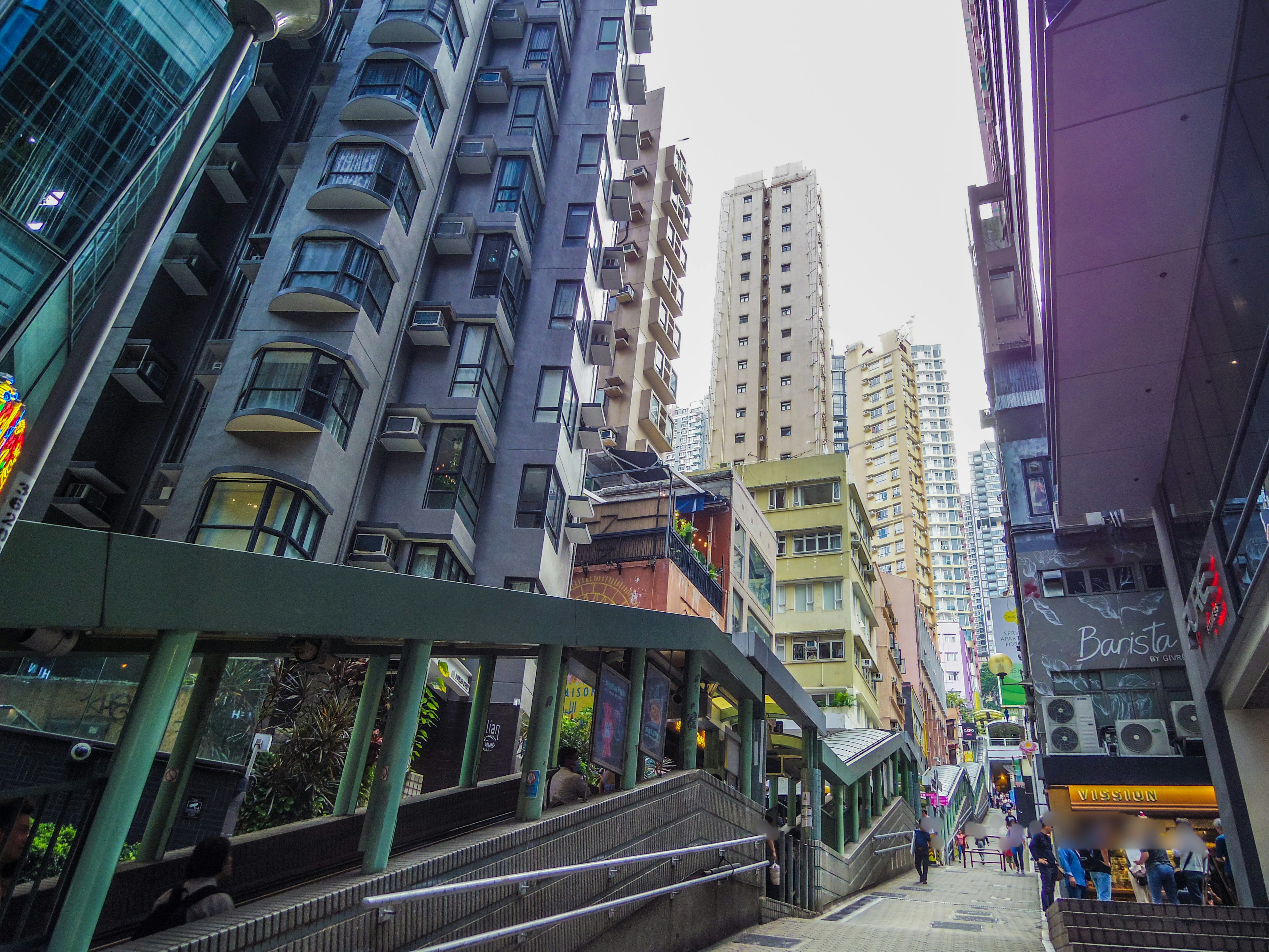 Scène de rue à Hong Kong avec des immeubles en hauteur et une rampe inclinée