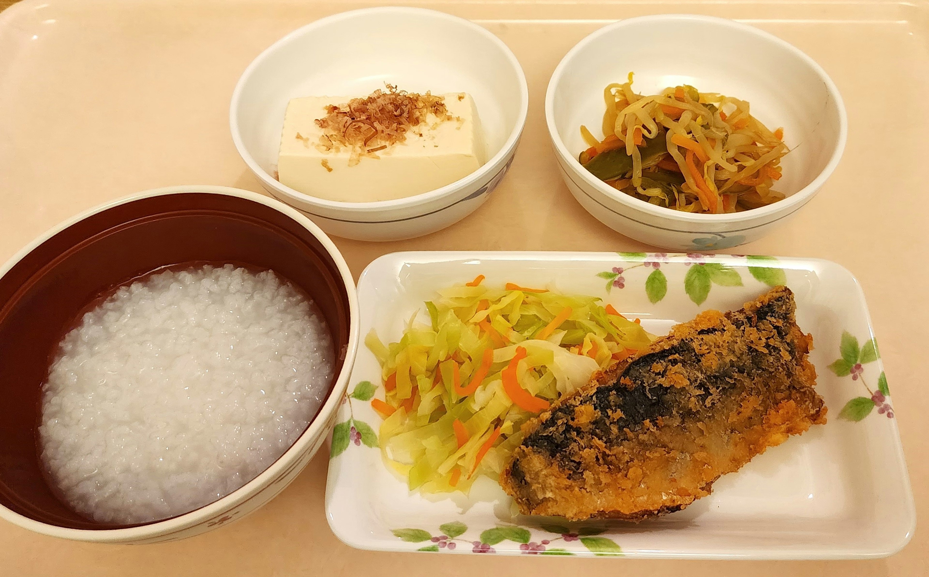 Un pasto con riso bianco, pesce alla griglia, insalata e tofu