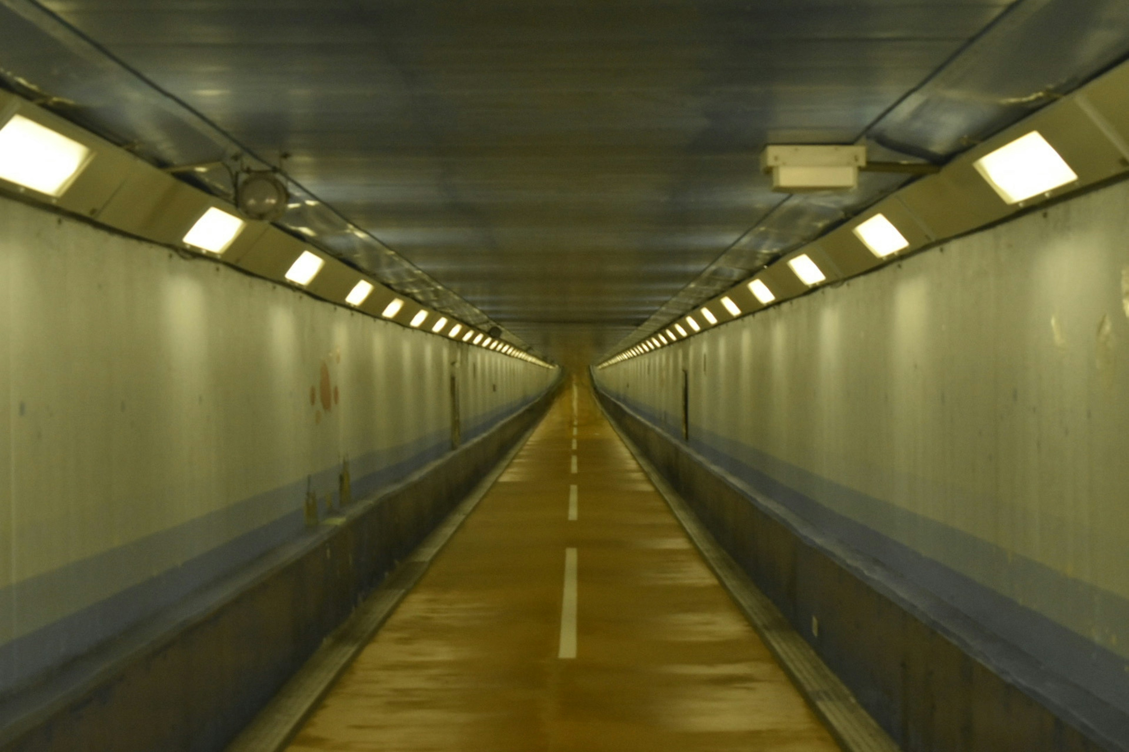 Interior view of a long tunnel with bright lighting