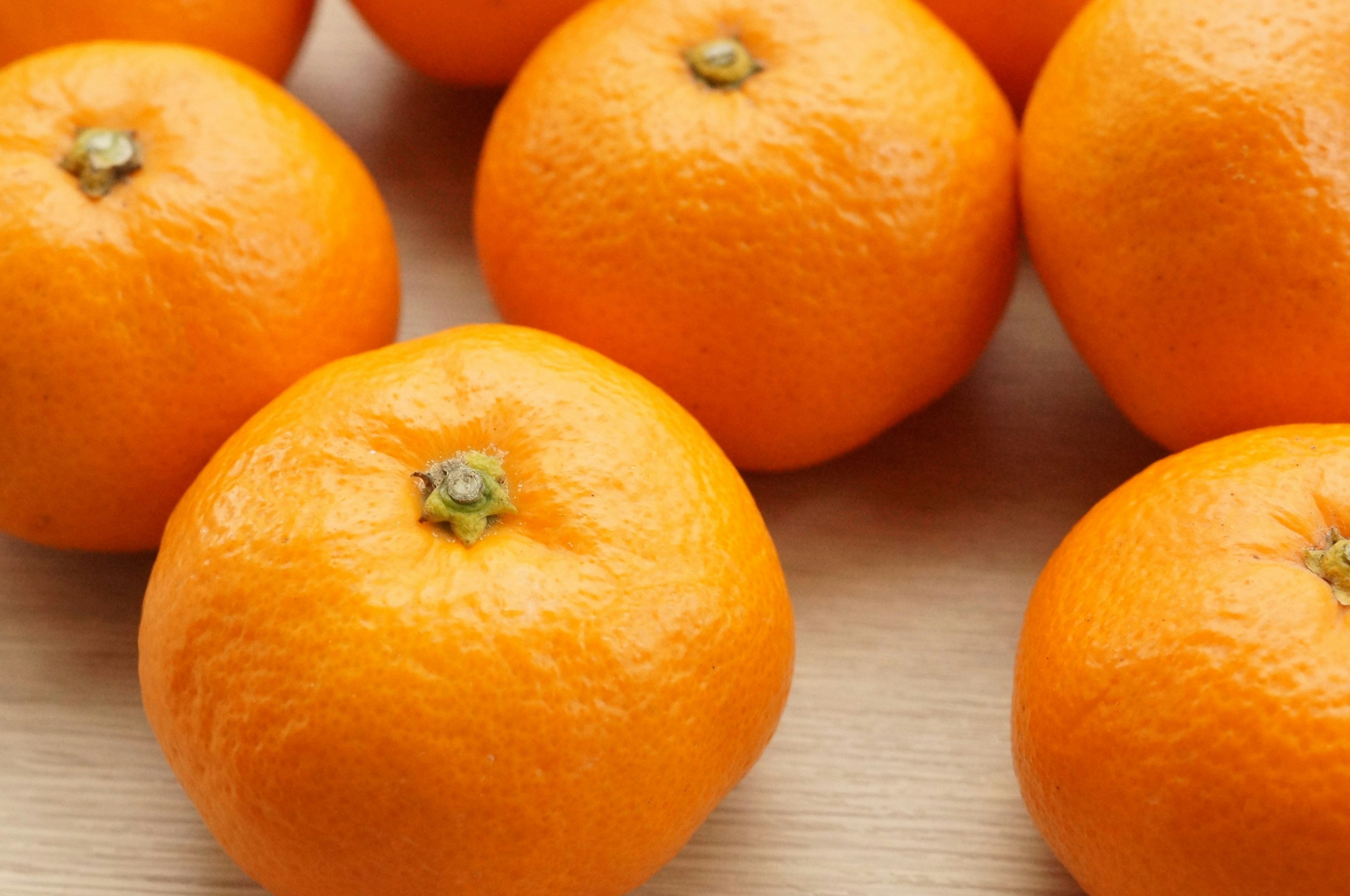 Vibrant oranges arranged on a wooden surface