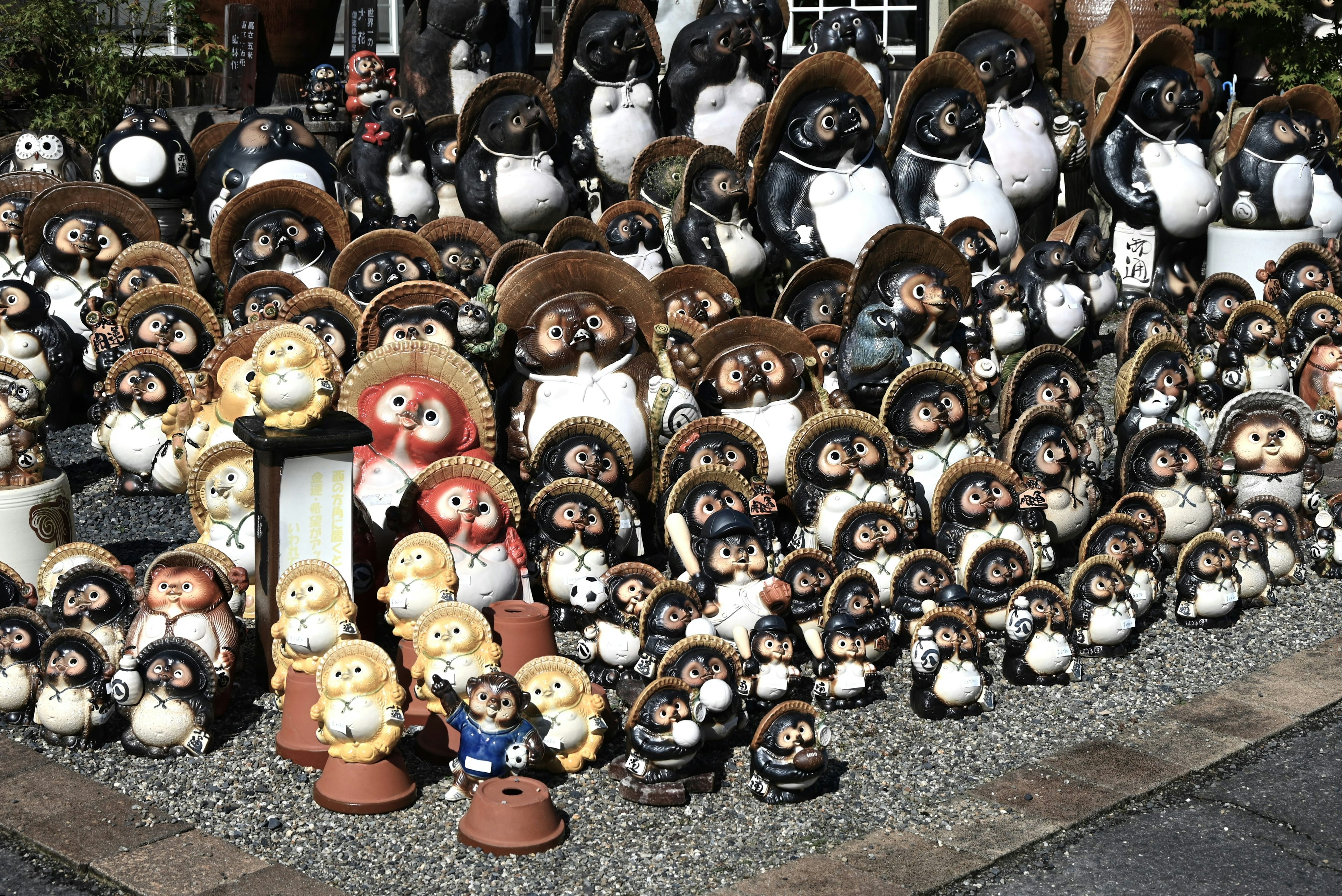 A variety of ceramic figurines displayed including black and white penguin shapes and other animal designs