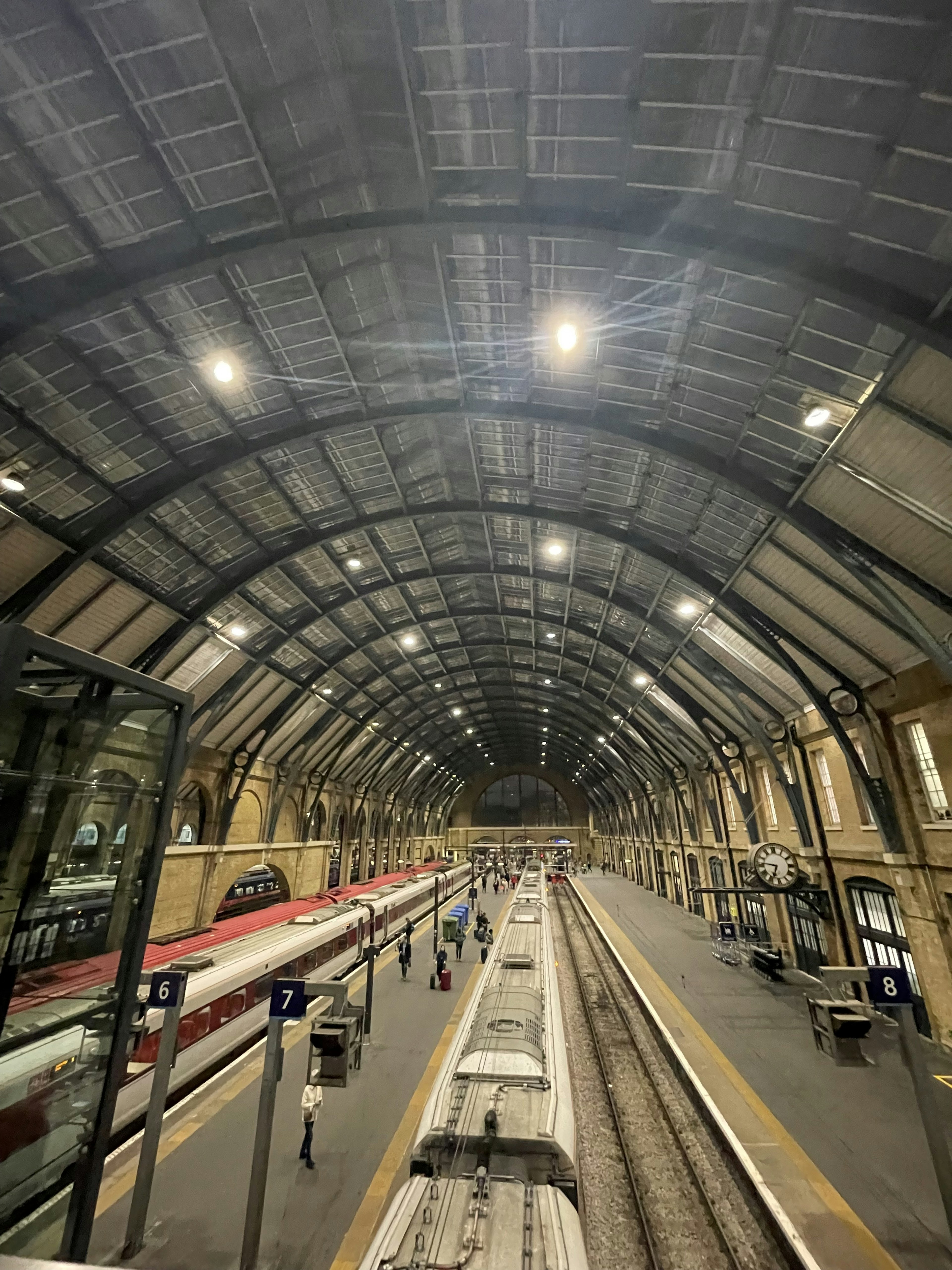 Stasiun kereta dengan langit-langit melengkung dan pencahayaan cerah