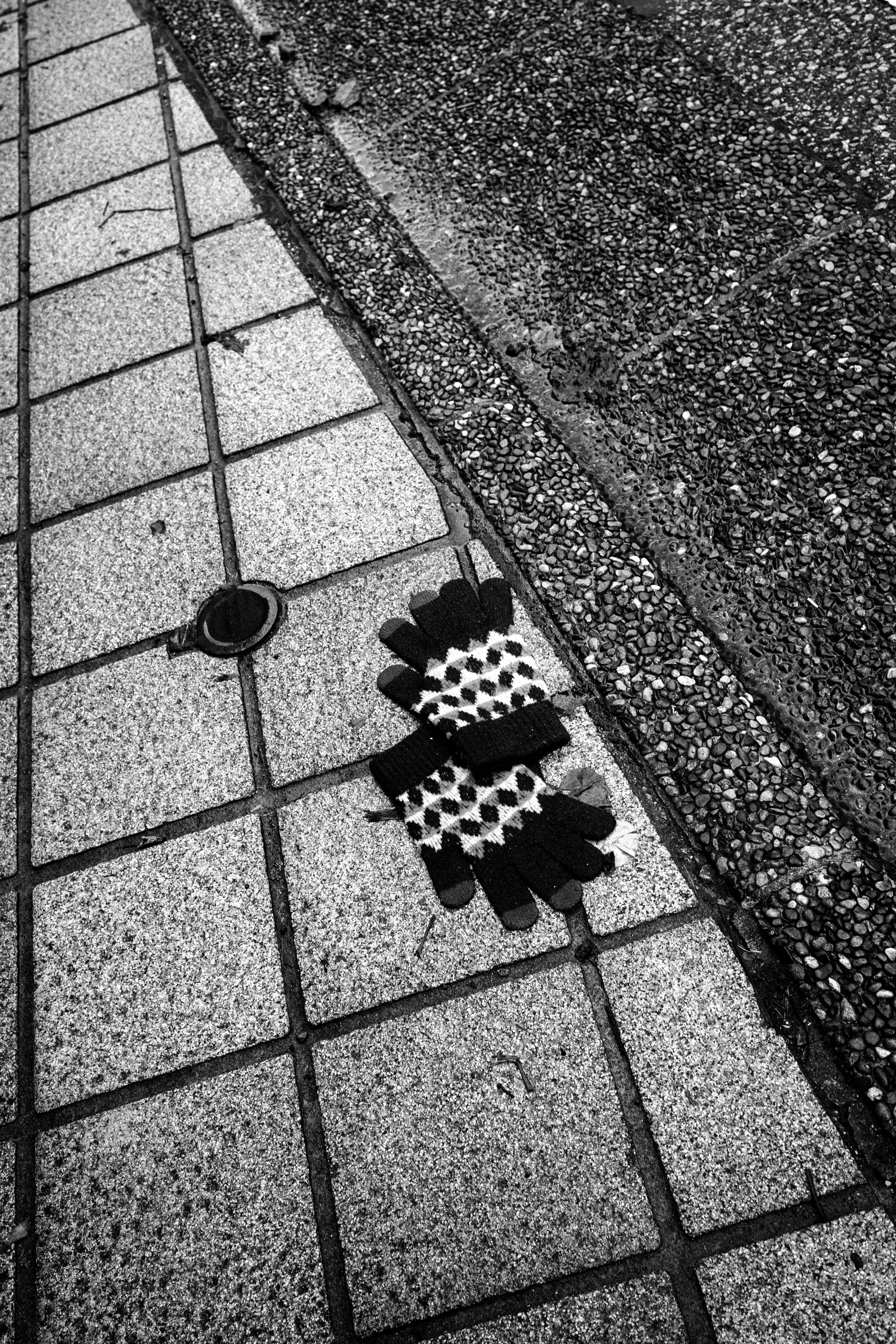 Black and white checkered gloves laid on the sidewalk