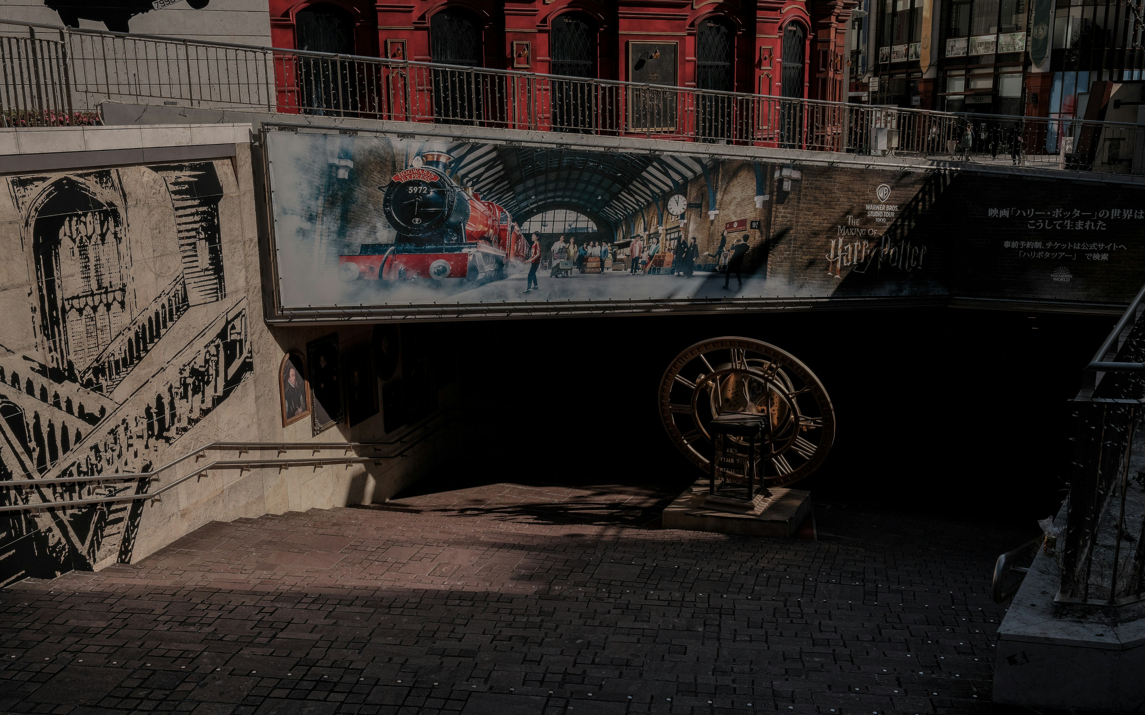 Vibrant graffiti on an underpass wall with a large wheel in a city setting