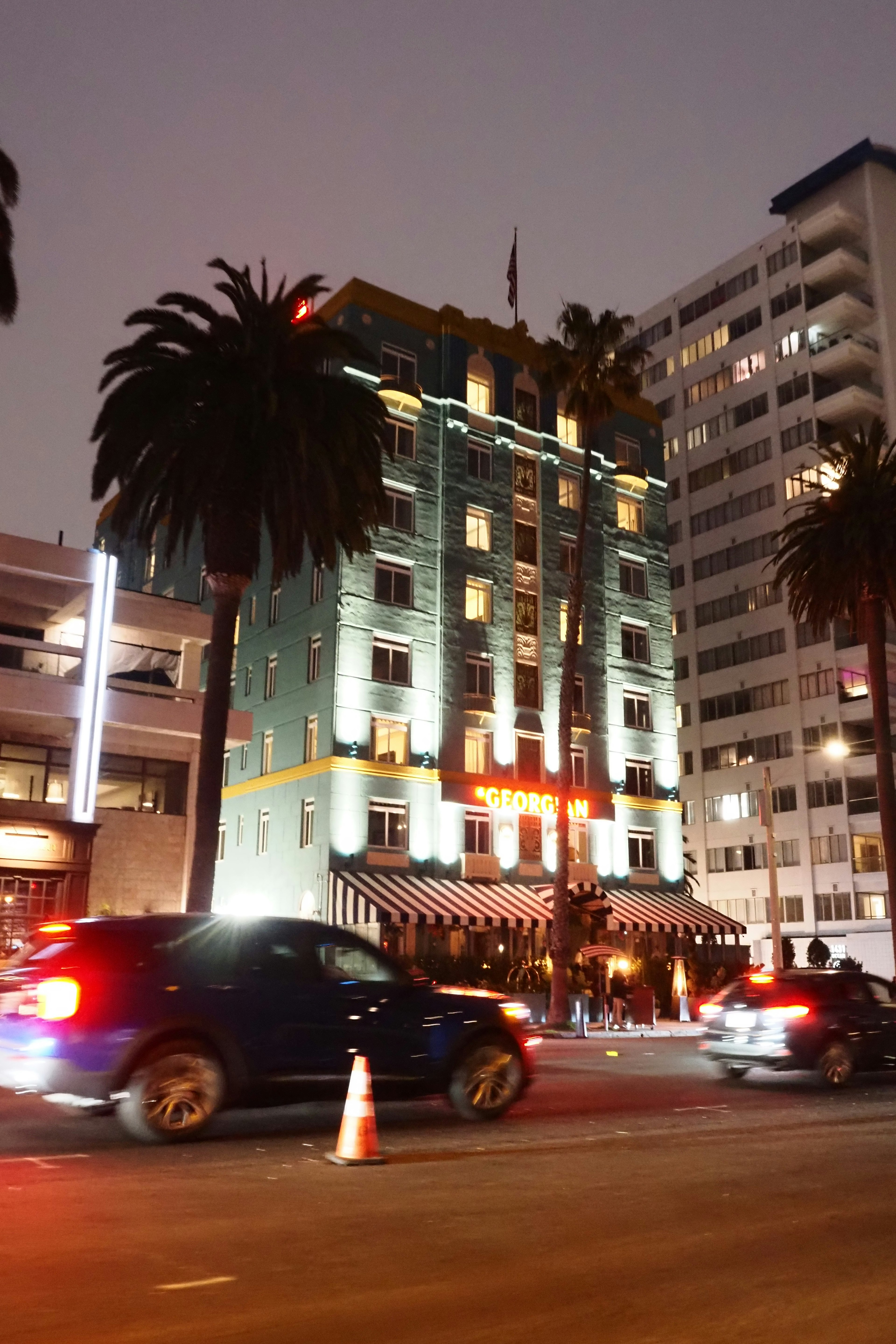 Historic blue building with palm trees at night