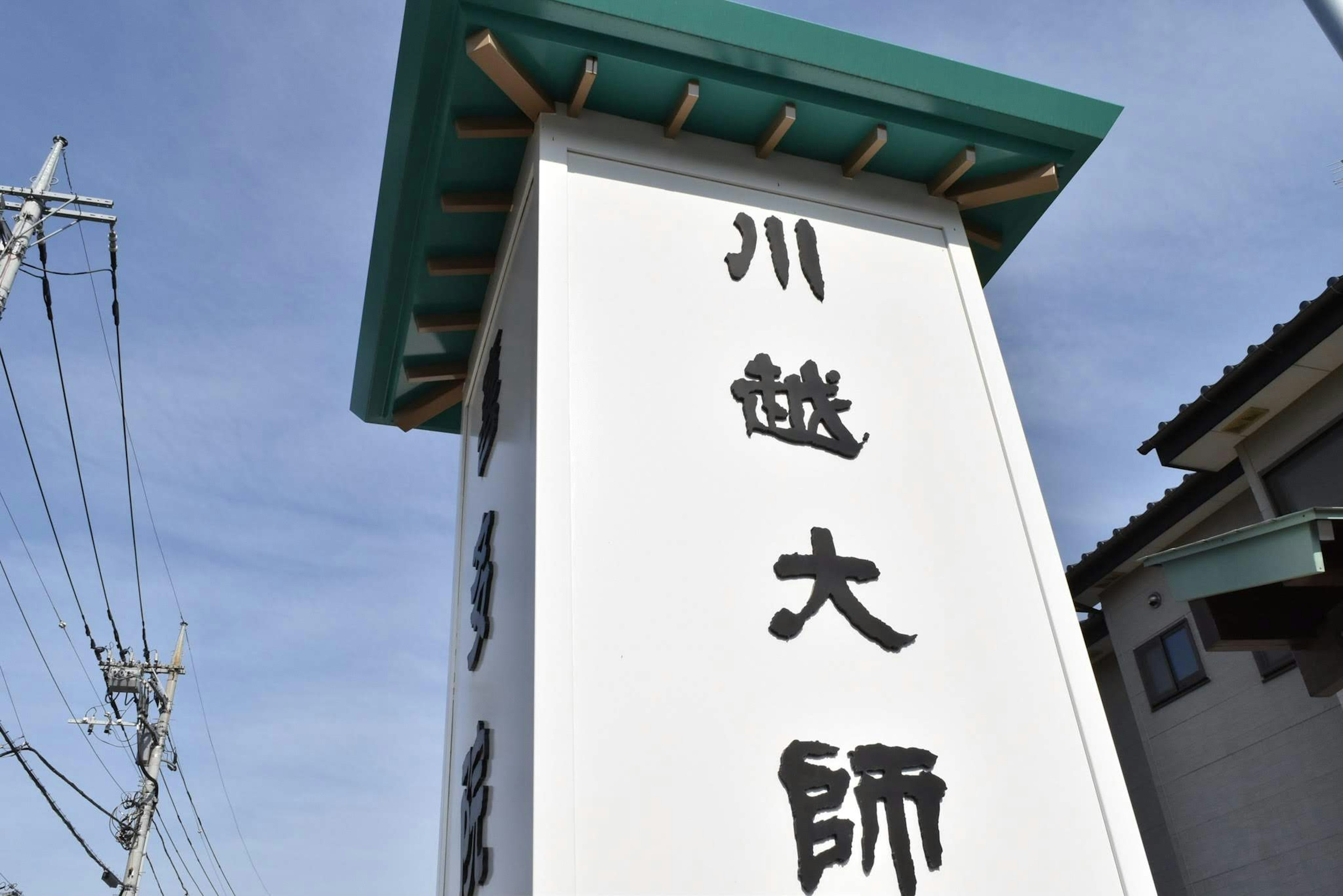 Weißes Schild von Kawagoe Daishi mit grünem Dach