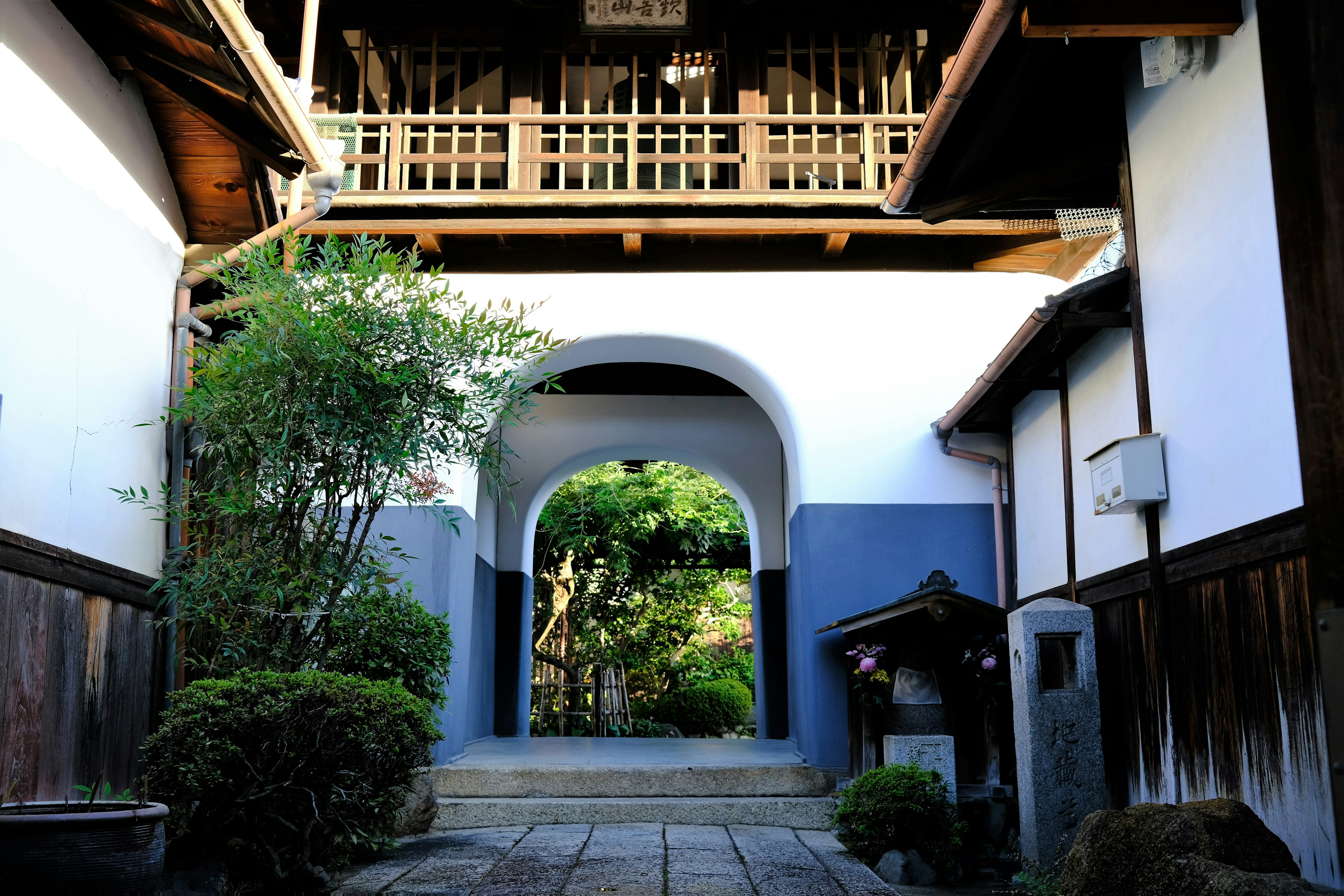 Belle entrée en arc avec une architecture japonaise traditionnelle et un jardin verdoyant